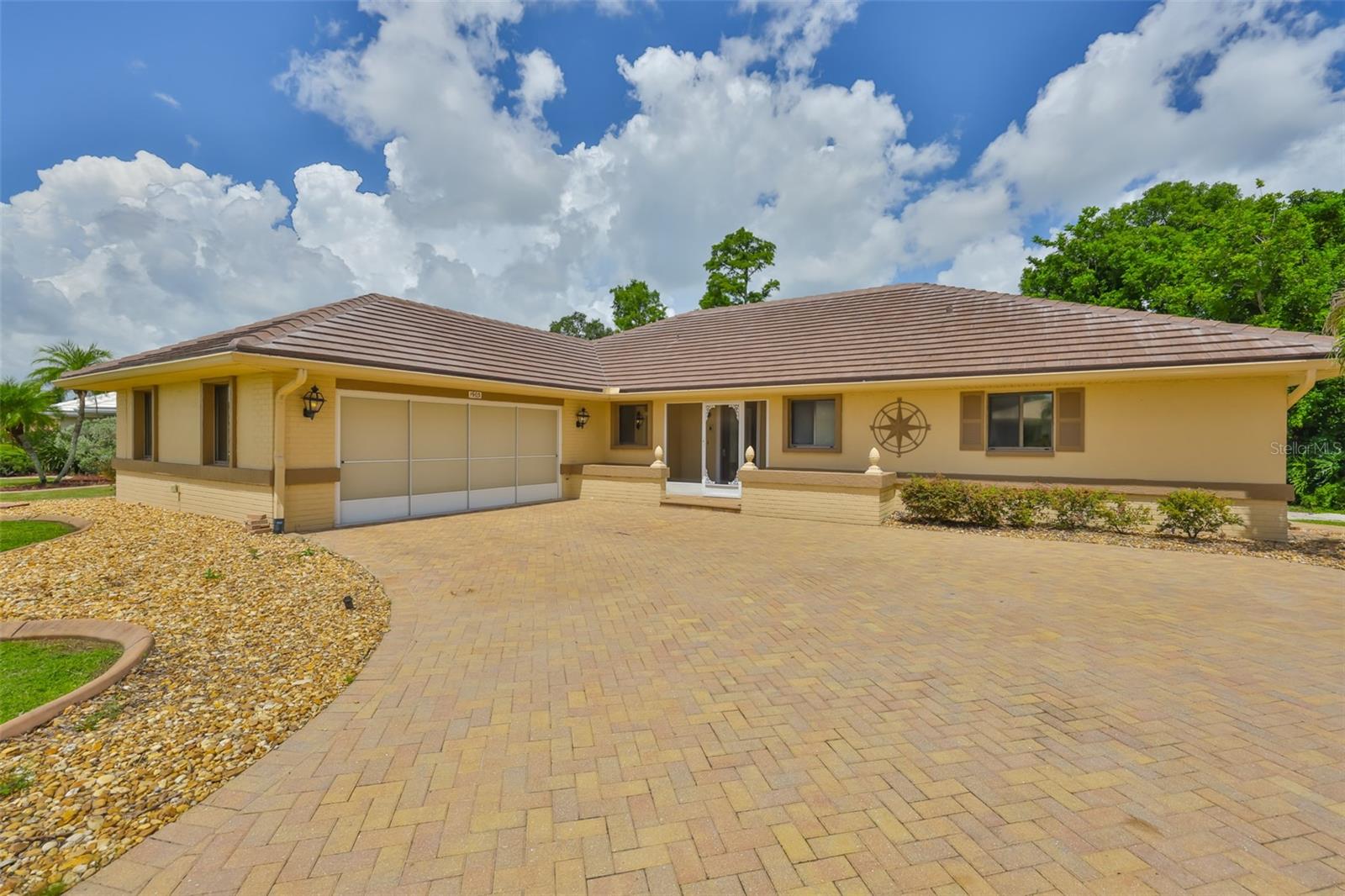 One stand out feature is the expansive custom paved driveway, providing plenty of room for multiple vehicles, guest parking, or even recreational vehicles. Notice the screens on the New Hurricane Impact Garage door.