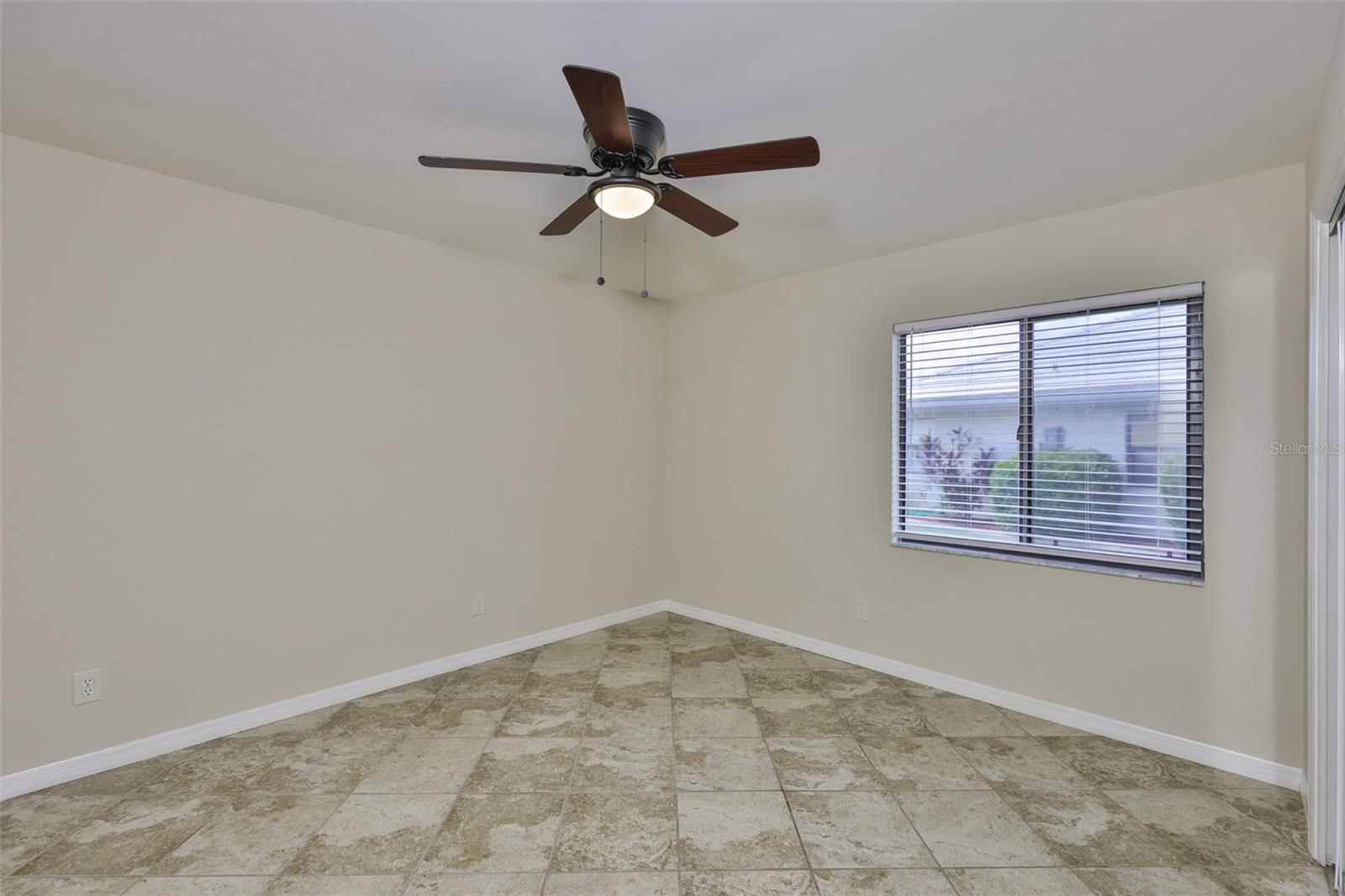 Large guest bedroom #2 with ceiling fan and large window for natural sunshine.