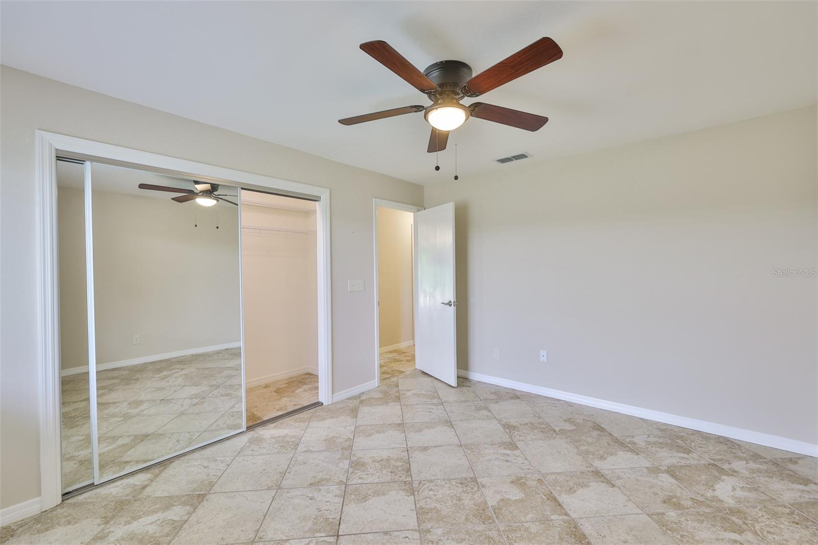 Large built in tiled wall closet with sliding doors in bedroom #2