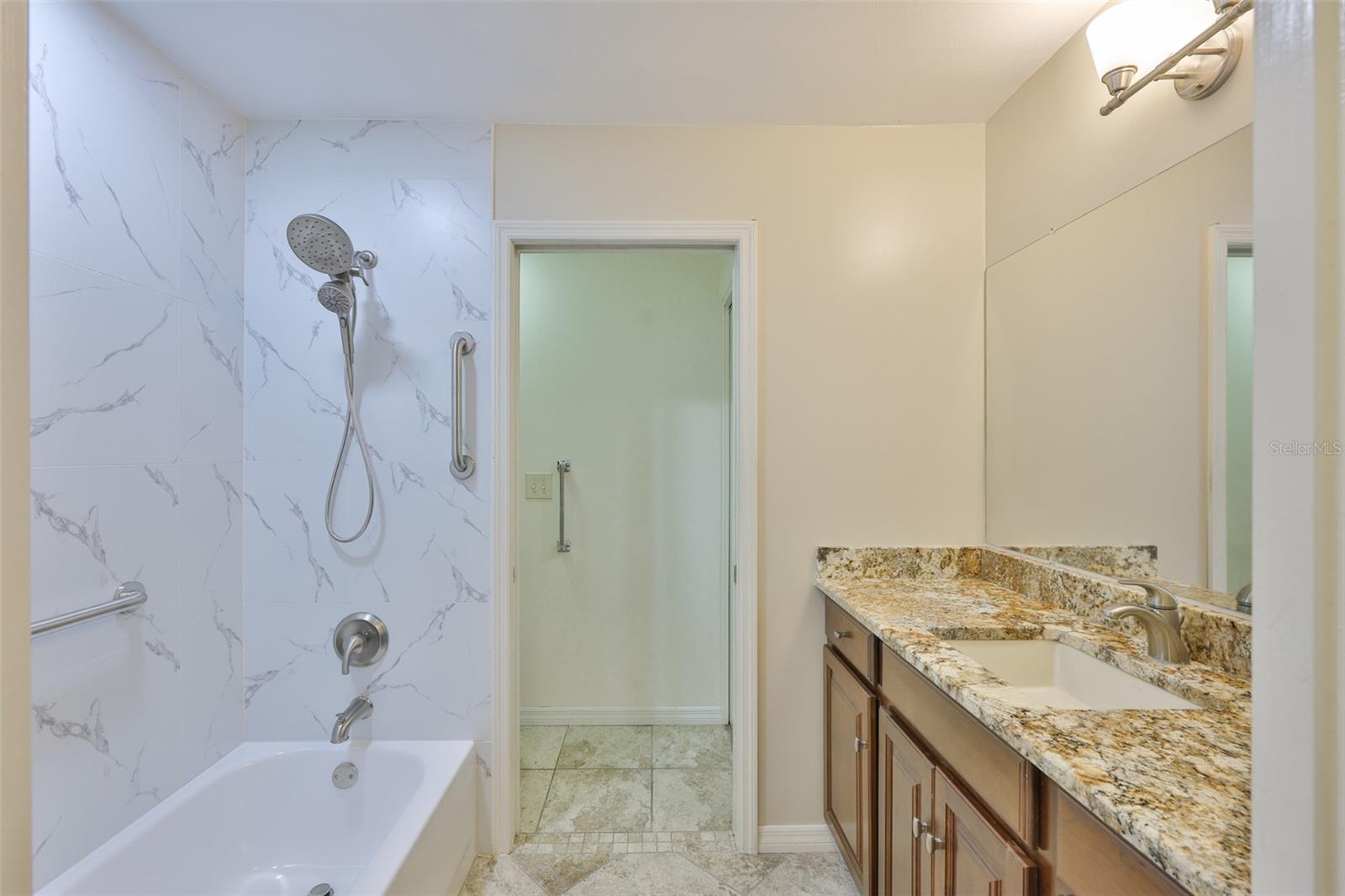 Guest Bathroom is bright and clean with updated granite countertops and remodeled tub/shower combination and private water closet.