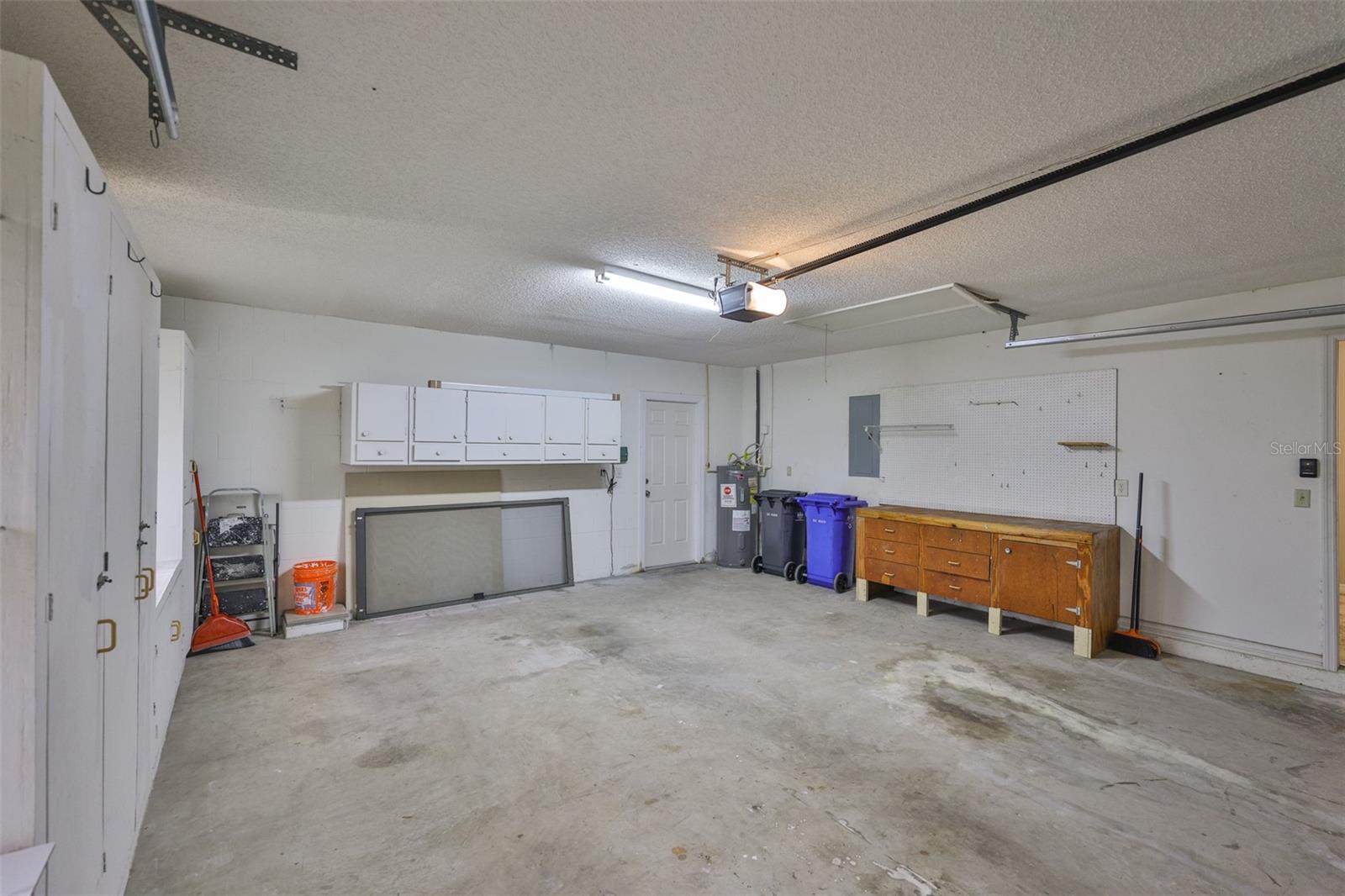 The oversized garage offers ample storage with workbench space to design, create, and build. There are lots of cabinets as well as a work bench.