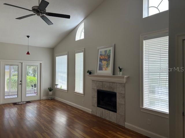 Family room facing rear of townhome with high volume ceiling & wood burning fireplace. French doors open to screened-in back porch.