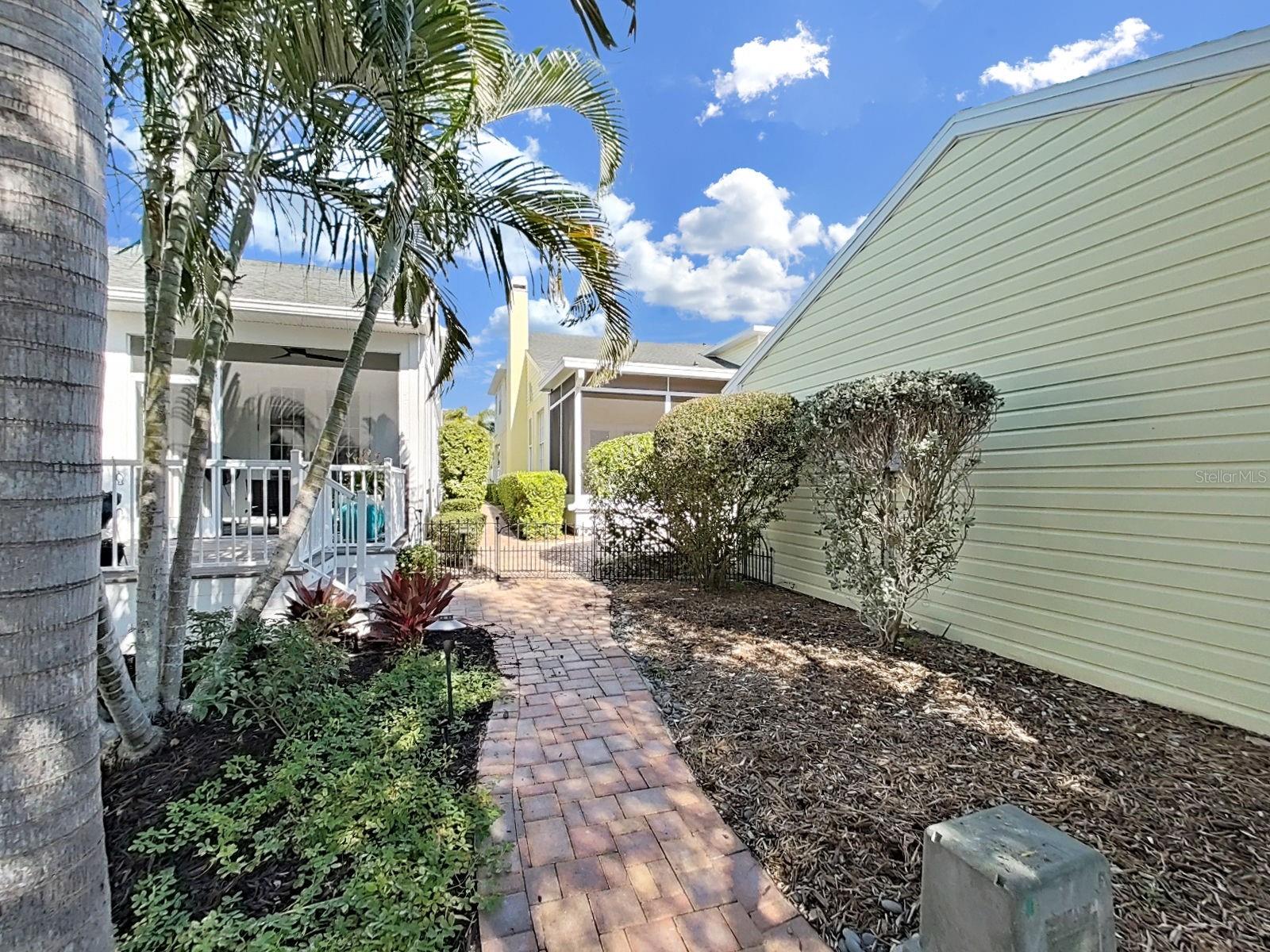 Back yard with brick paver sidewalk.