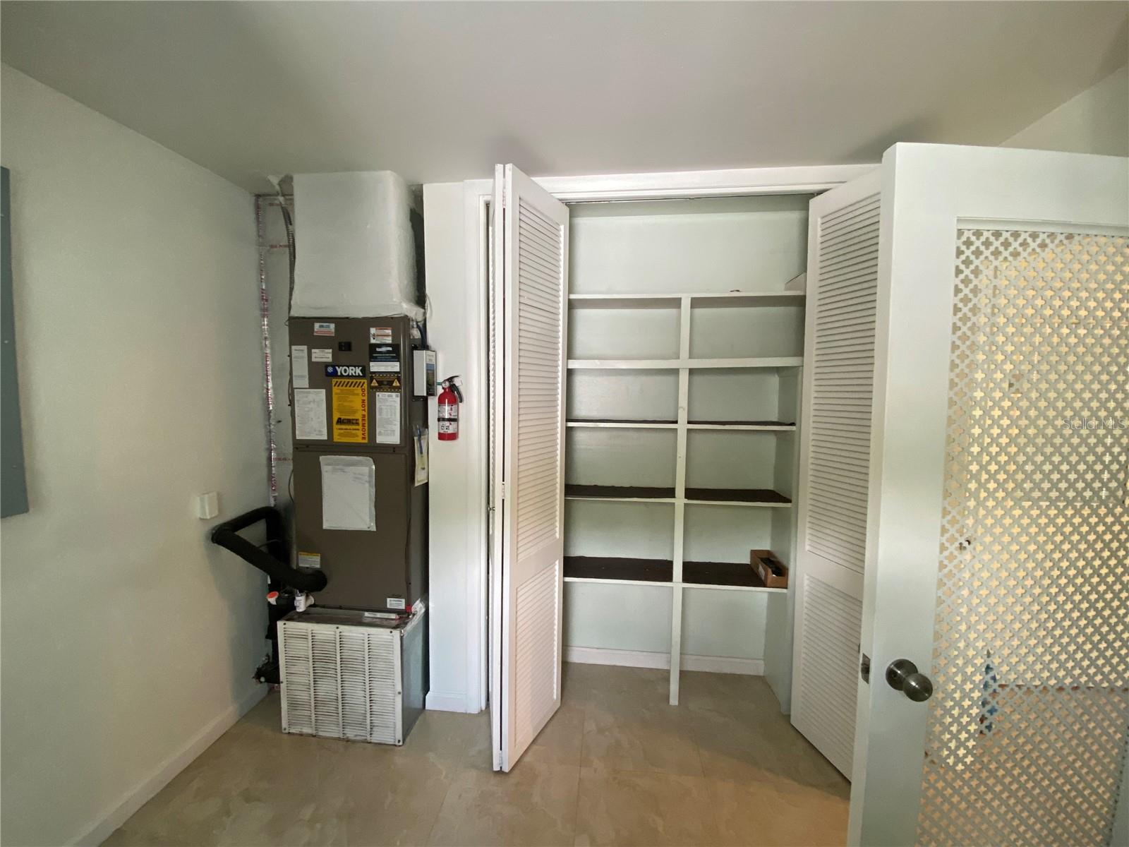 Indoor utility room-pantry shelves and AC handler