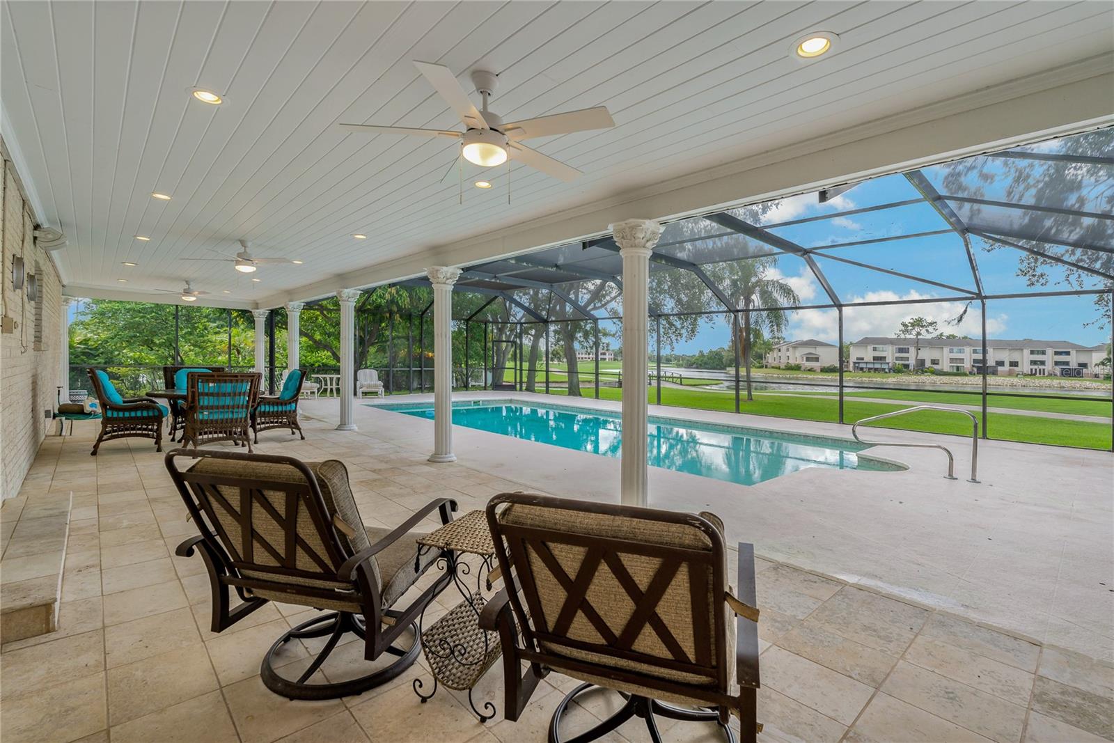 COVERED PATIO SPACE, SCREENED IN POOL OVERLOOKING THE 18TH TEE AT FEATHER SOUND COUNTRY CLUB