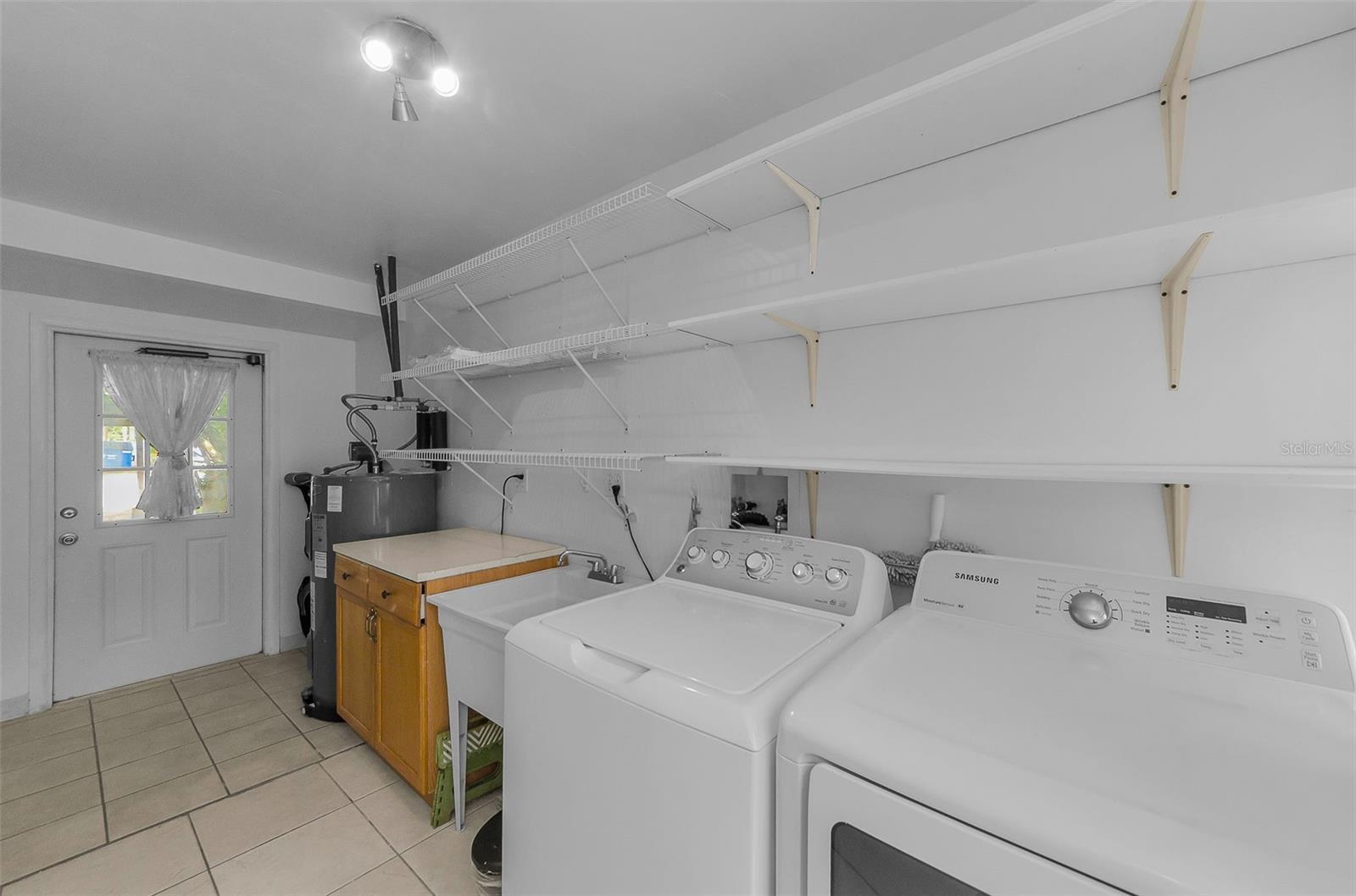 Laundry room with door leading to front side yard