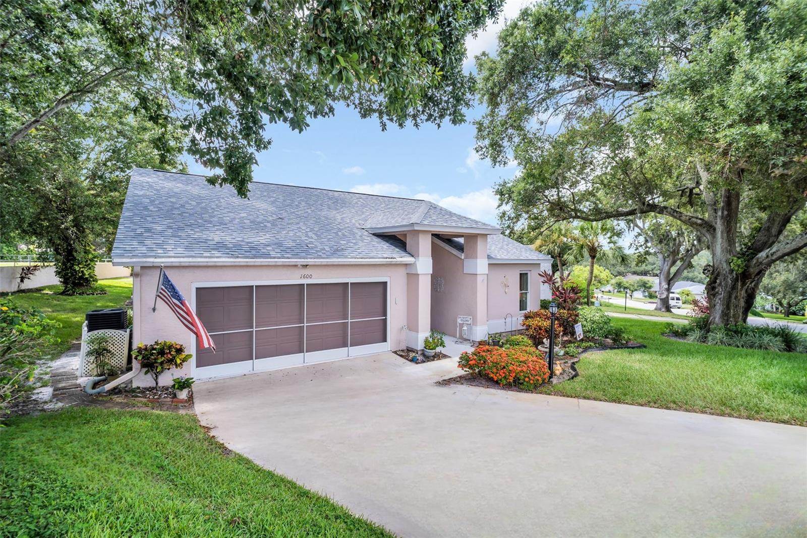 Surrounded by lush green landscaping, updated windows, garage door & screen~