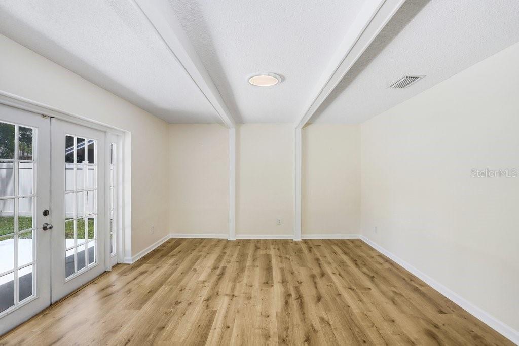 Gorgeous living area complimented by French doors leading to the backyard and beams along the ceiling for added charm!