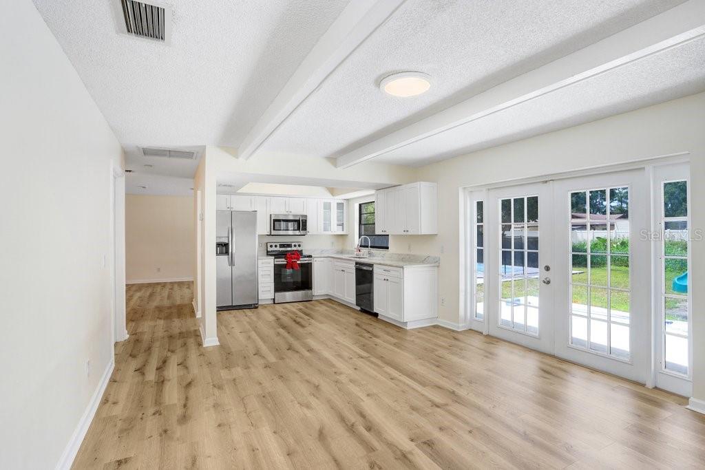 Gorgeous living area complimented by French doors leading to the backyard and beams along the ceiling for added charm!
