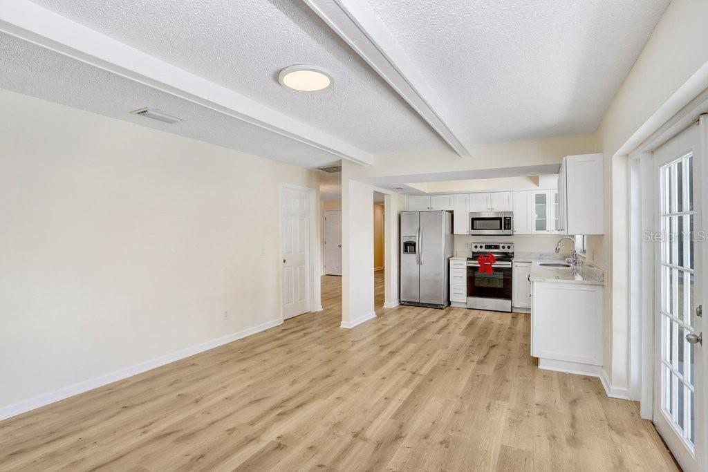 Gorgeous living area complimented by French doors leading to the backyard and beams along the ceiling for added charm!