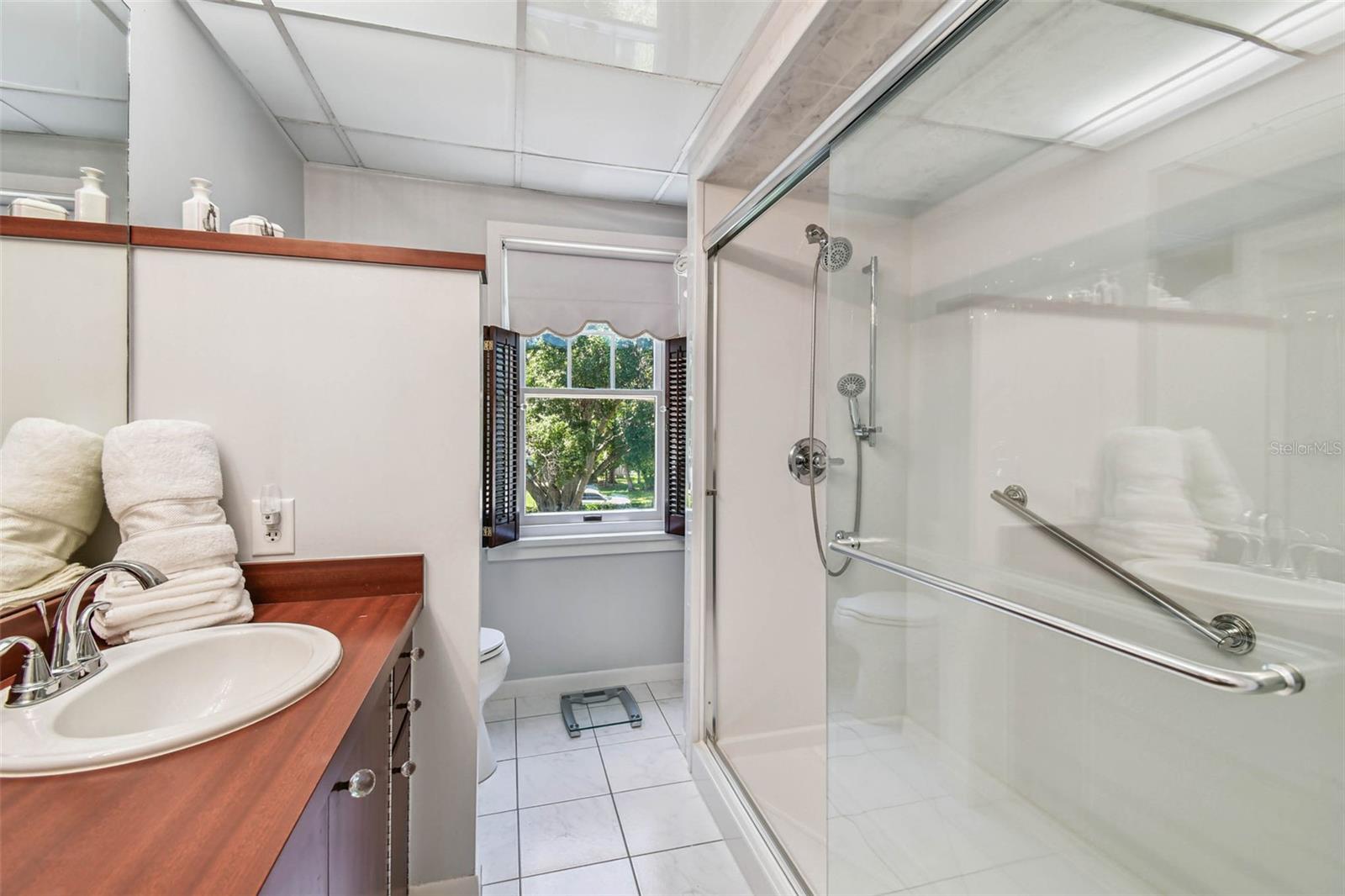 Updated shower with glass sliding door.