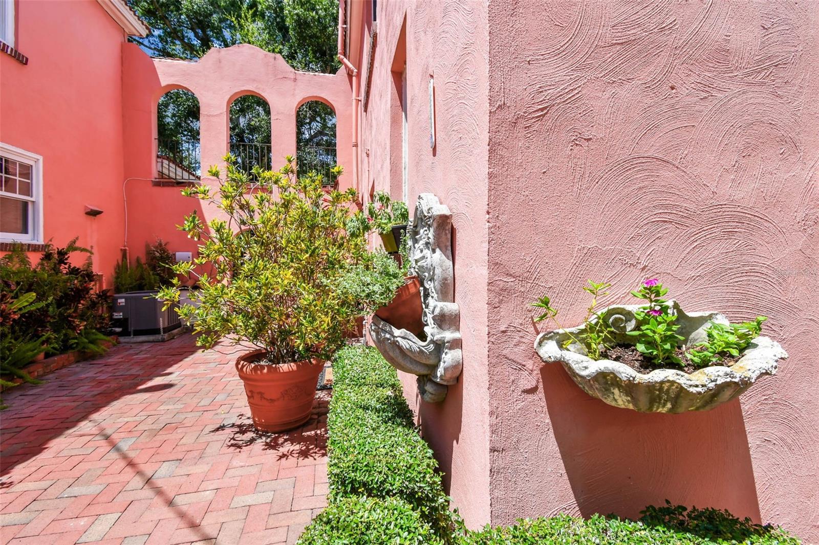 Courtyard with plants. Table and chairs on other end.