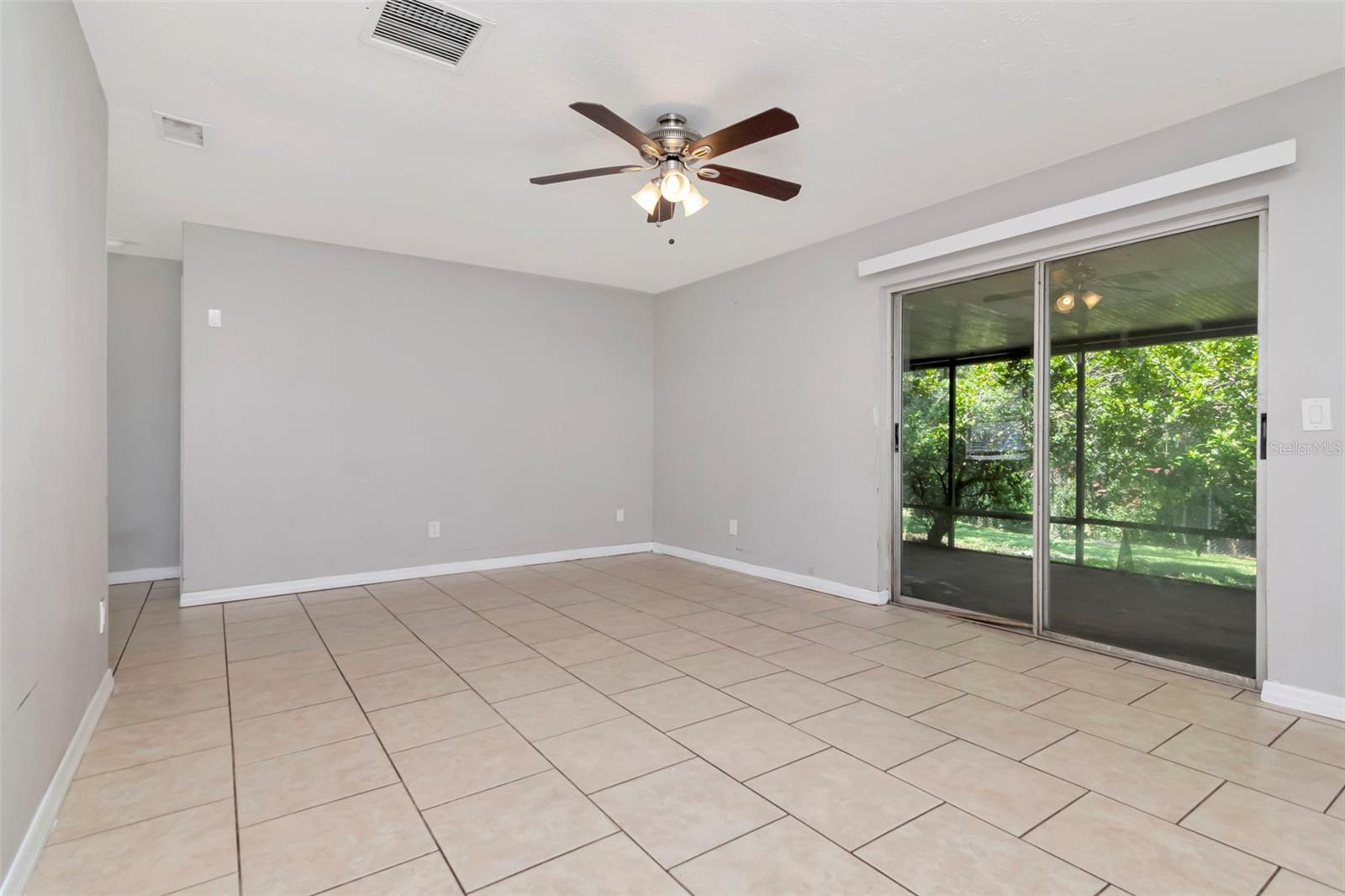 The living room features sliding glass doors to the screened, covered, lanai and the backyard.