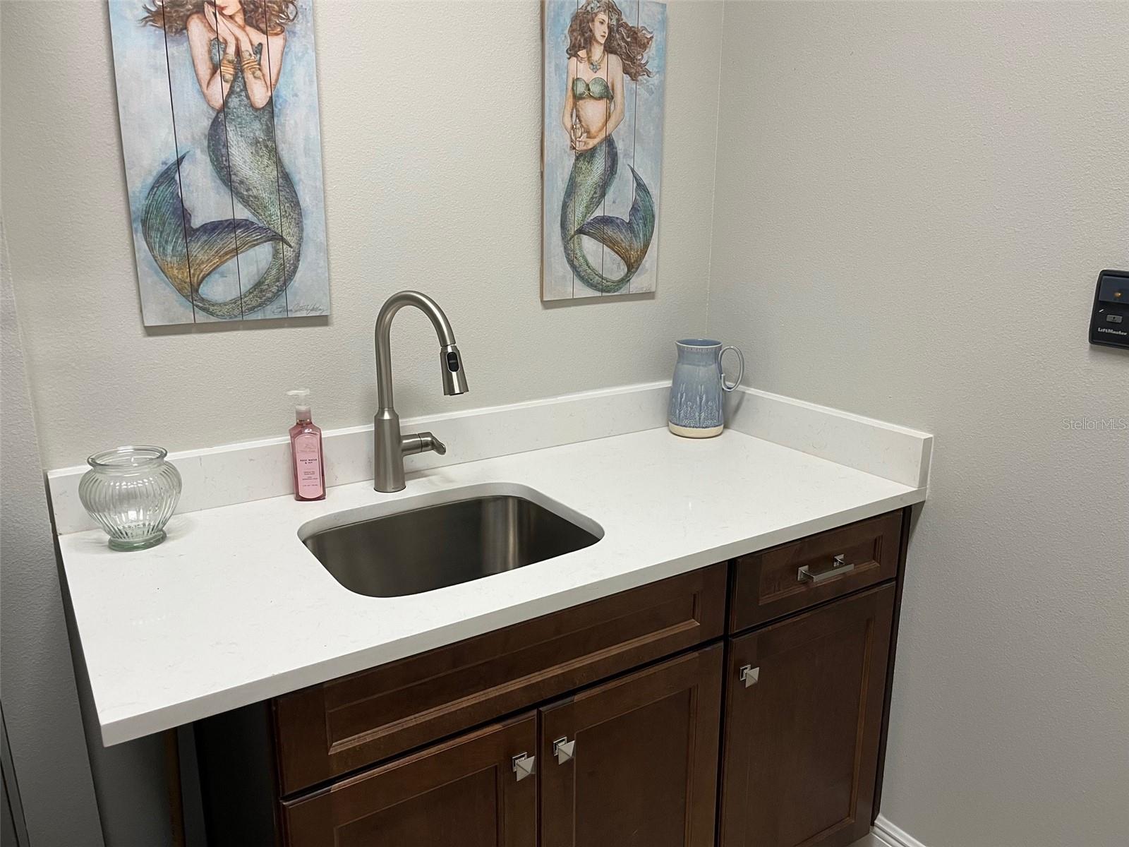 laundry room sink and storage. Yes that is quartz and the original faucet taken from kitchen