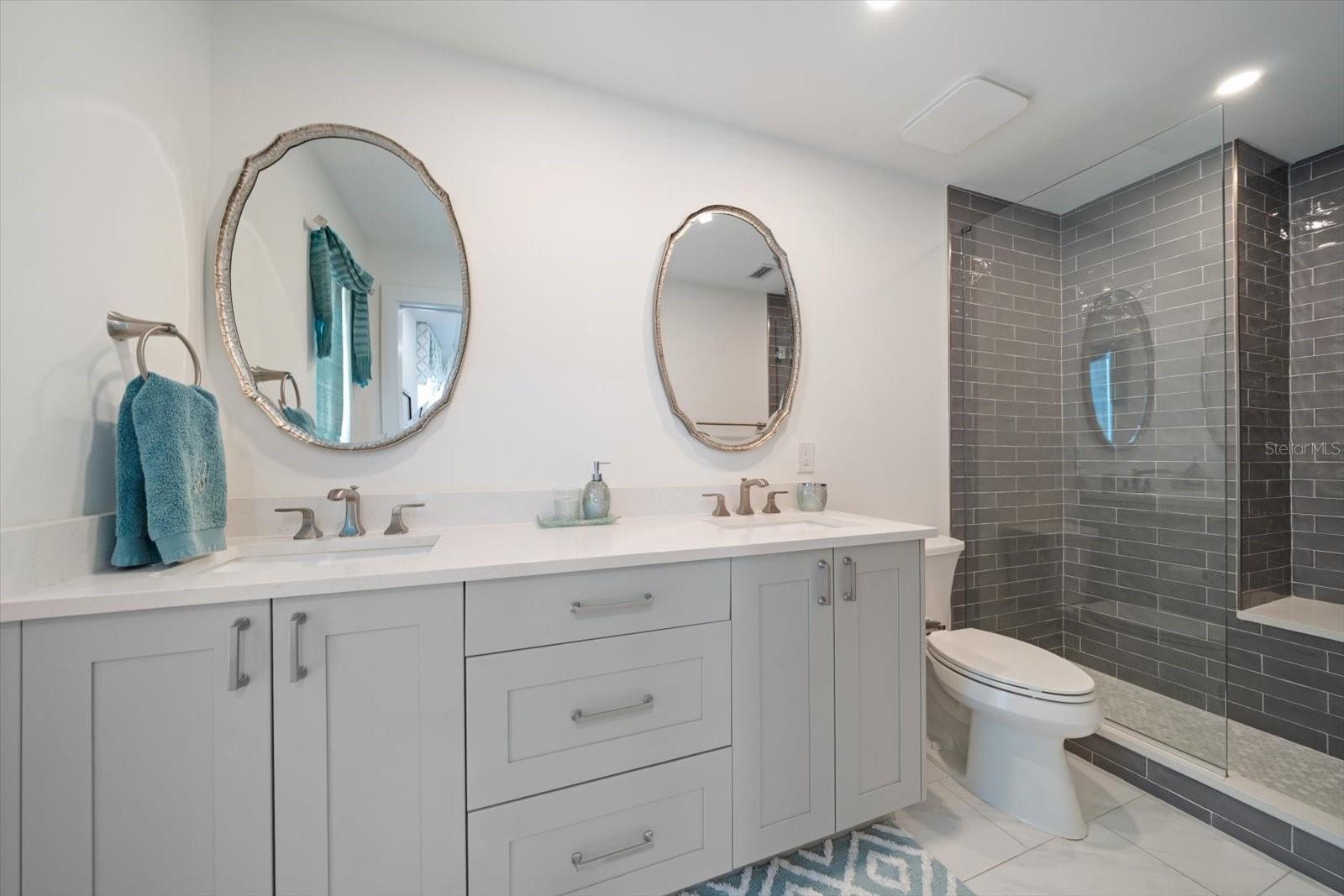 Primary bath with double vanity and attractive tile and quartz applications.