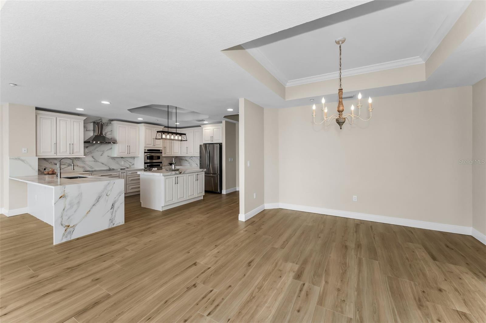... Dining Area with Chandelier on Right. Open Kitchen on Left.. Modern Open Layout - Entire Great Room Area is MOL 1100 Sq FT.. New Flooring - Woodville Natural Wood Plank Porcelain Tile. New Wall Finish.