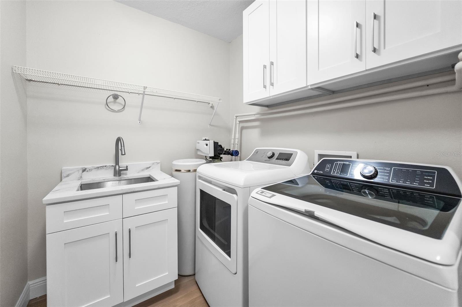 ..  11-by-6.5 Ft  Laundry Room With Extra Storage Space. All New Flooring, Cabinetry, Sink  And Washer & Dryer.  Water Softener 3 years old. .. Laundry Room is Located Next To  Kitchen Area For Convenient Access.