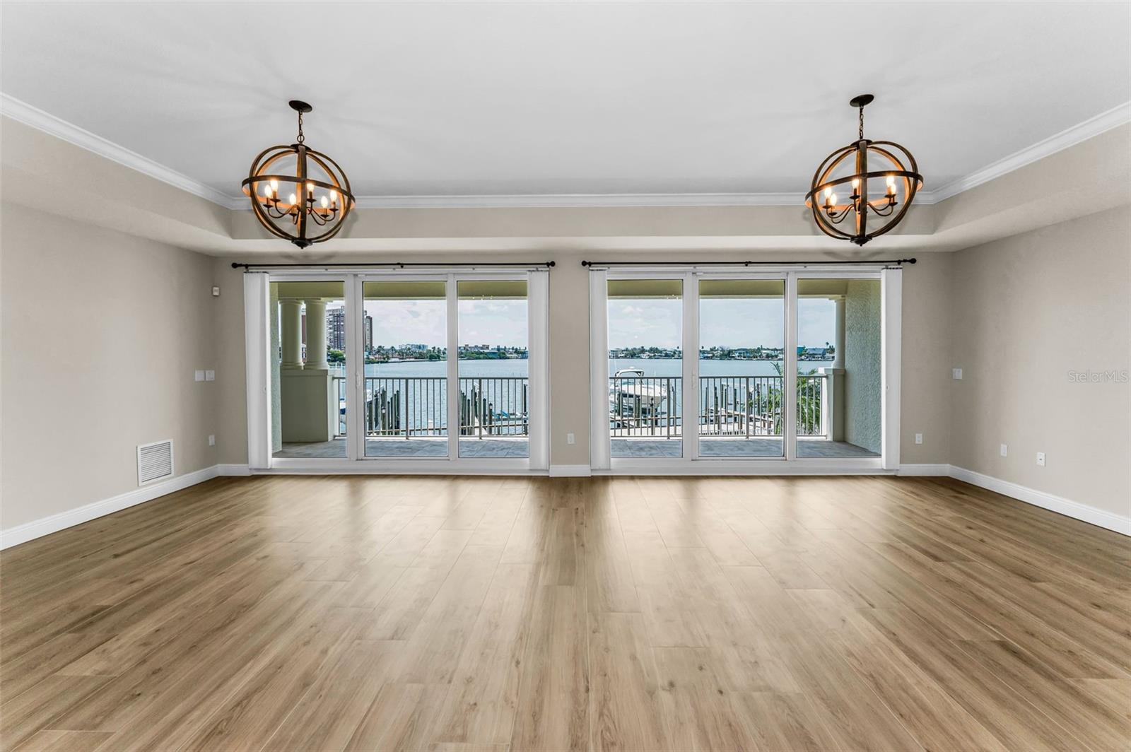 .. Remodeled Residence 202 comes with Raised Tray Ceilings  - 30 Foot Wide Floor to Ceiling High Impact Balcony Sliders Complete with Hunter Douglas Window Treatments. Wonderful background View of Boca Ciega Bay.. Remodeled - New Flooring - Woodville Natural Wood Plank Porcelain Tile.
