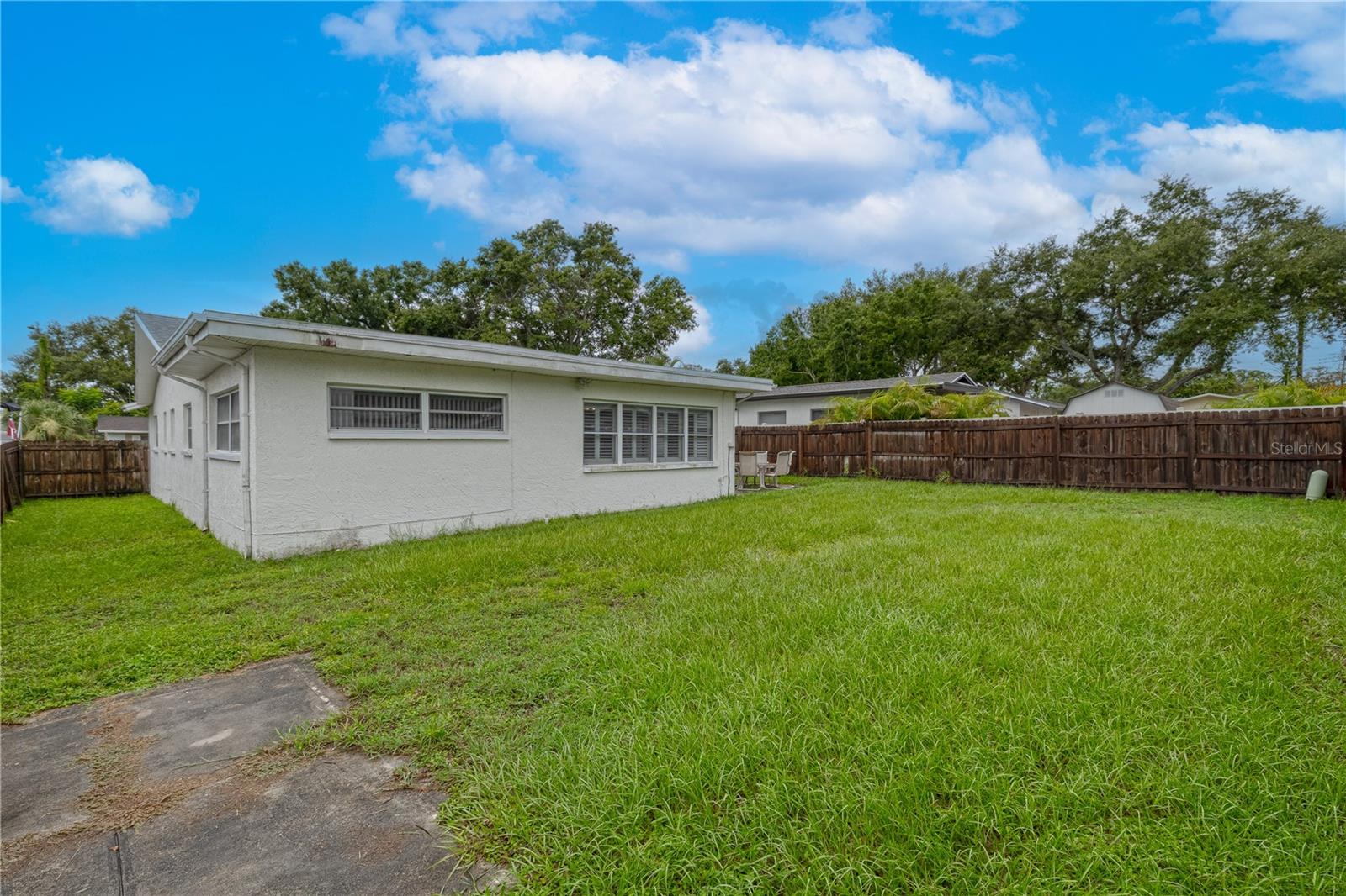 Expansive fenced backyard offering privacy and ample space for outdoor activities, entertaining, or future landscaping projects. The level grassy area is ideal for pets or play, with room to add a pool or garden.