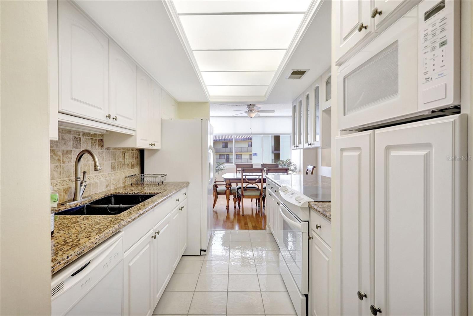 The kitchen has granit counter, dual sink, Range, Dishwasher, Microwave andlots of storage and leads directly to the dining area