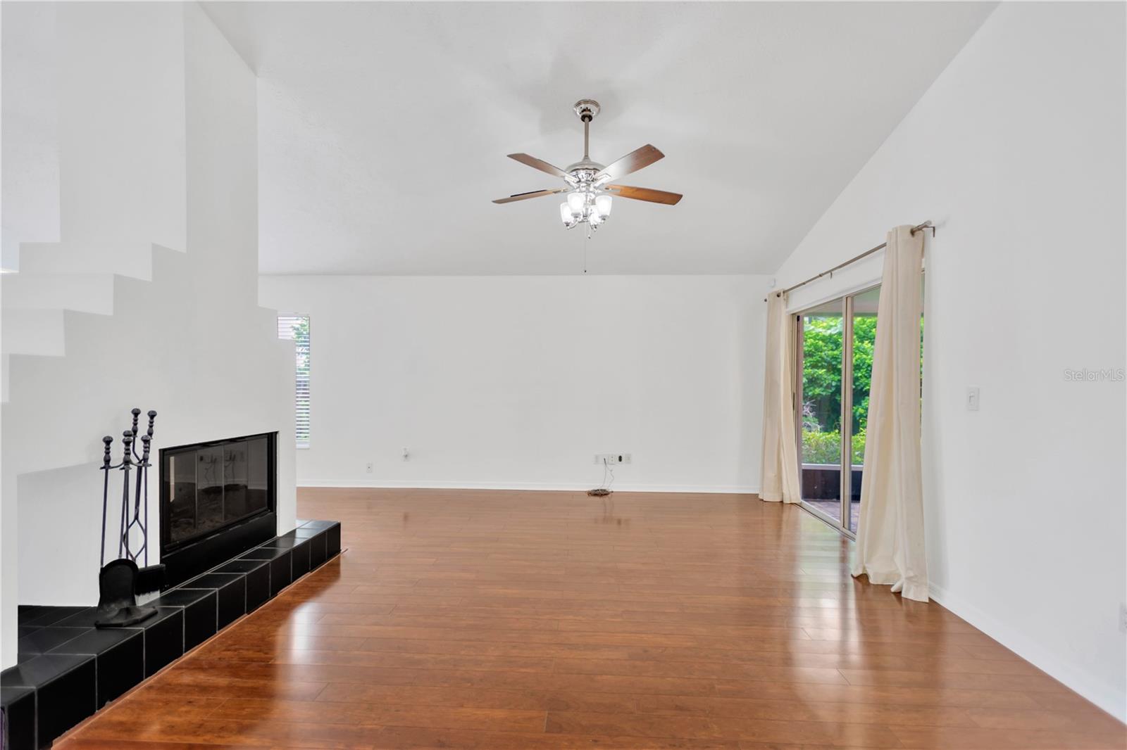 Spacious Living Room With Fireplace & Access to Back Screend In Patio