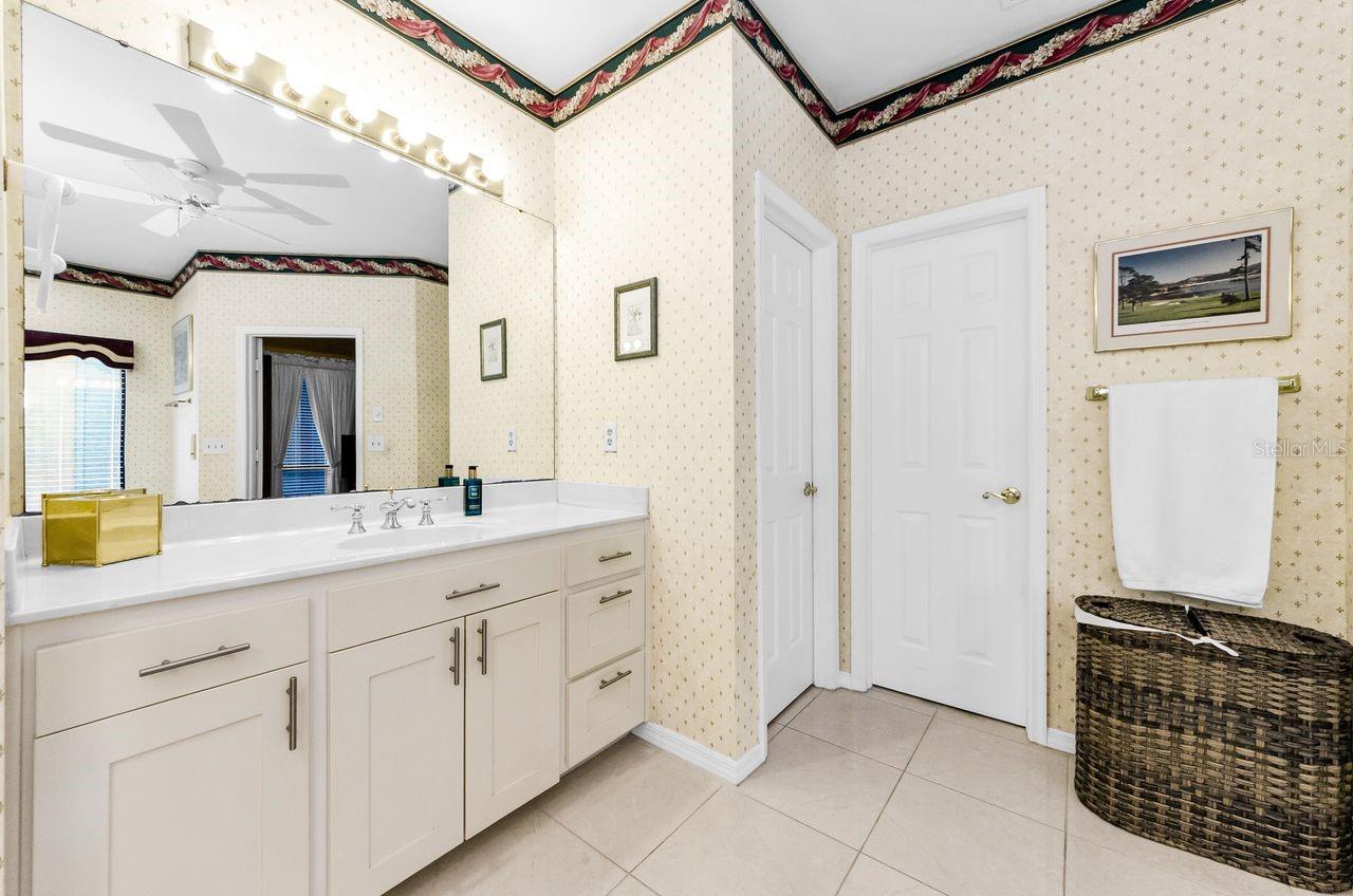 One of the vanities in the master bath. Private toilet room and walk in closet on the right.