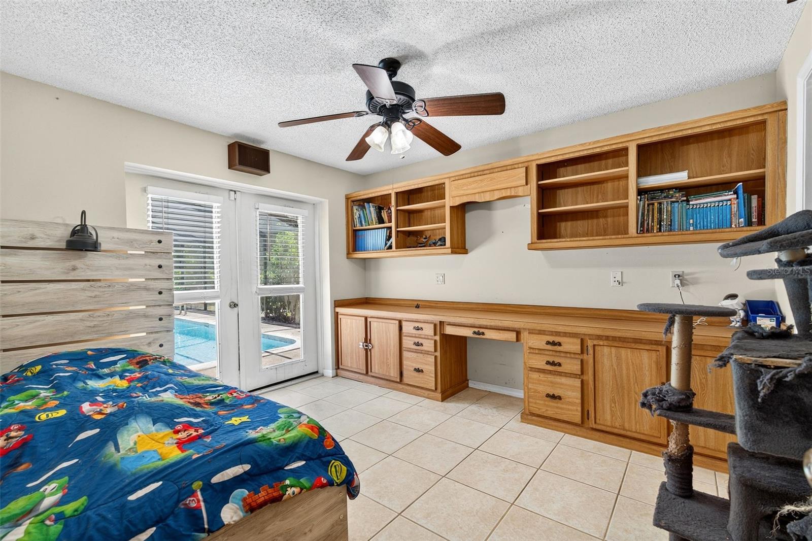 Built in shelving and desk with patio doors to the pool