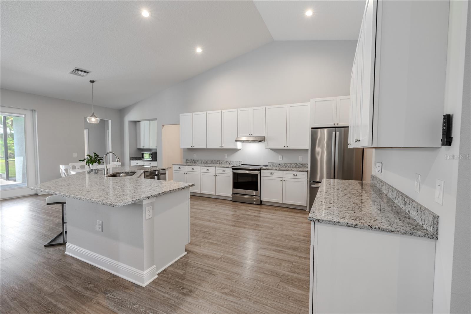 This stunning  kitchen boasts an expansive center island with breakfast bar seating, gleaming granite countertops, and abundant cabinet space for all your storage needs.