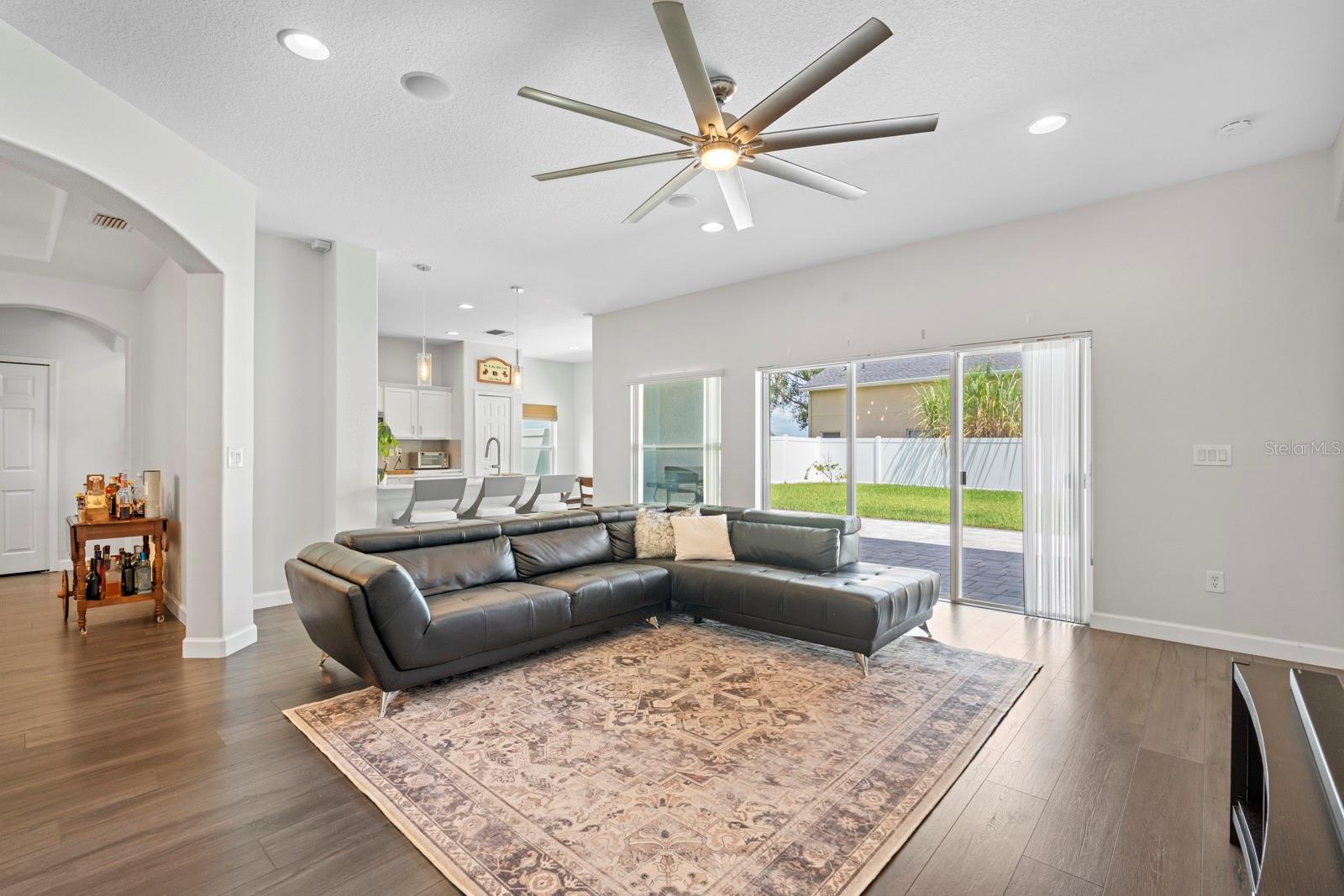 Living room with view of the fenced back yard and patio