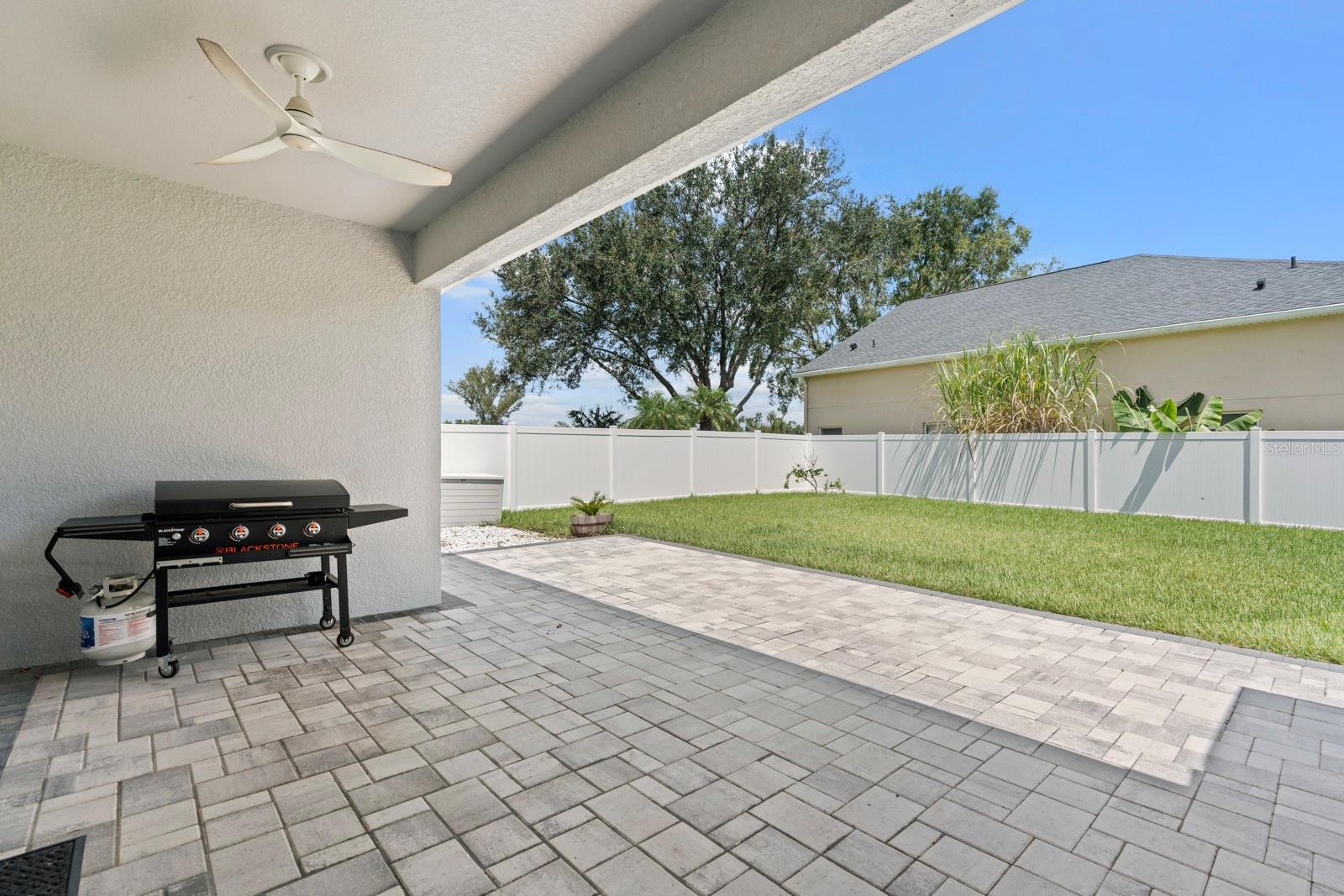 Backyard patio with pavers and fenced back yard