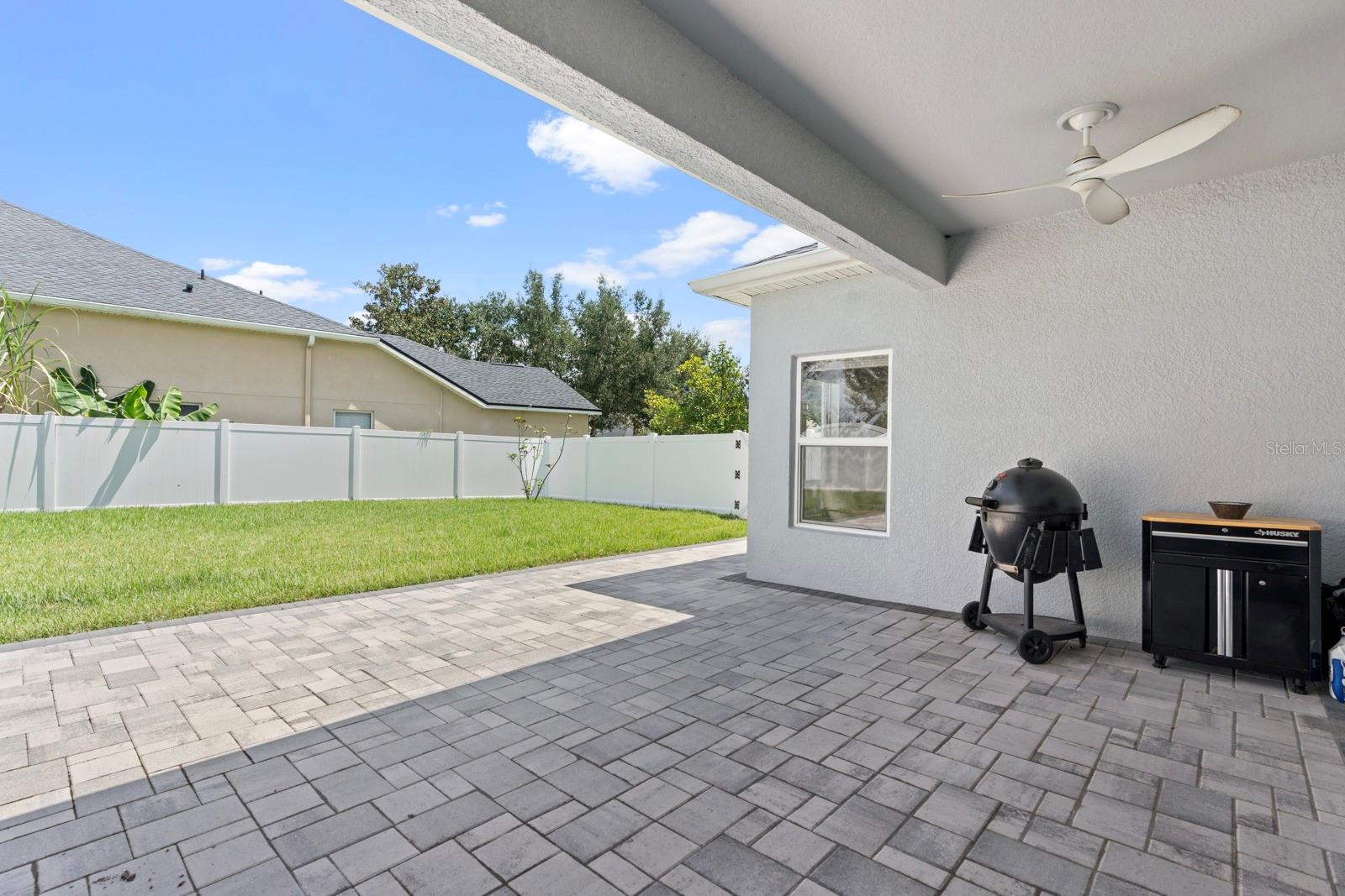 Backyard patio with pavers and fenced back yard