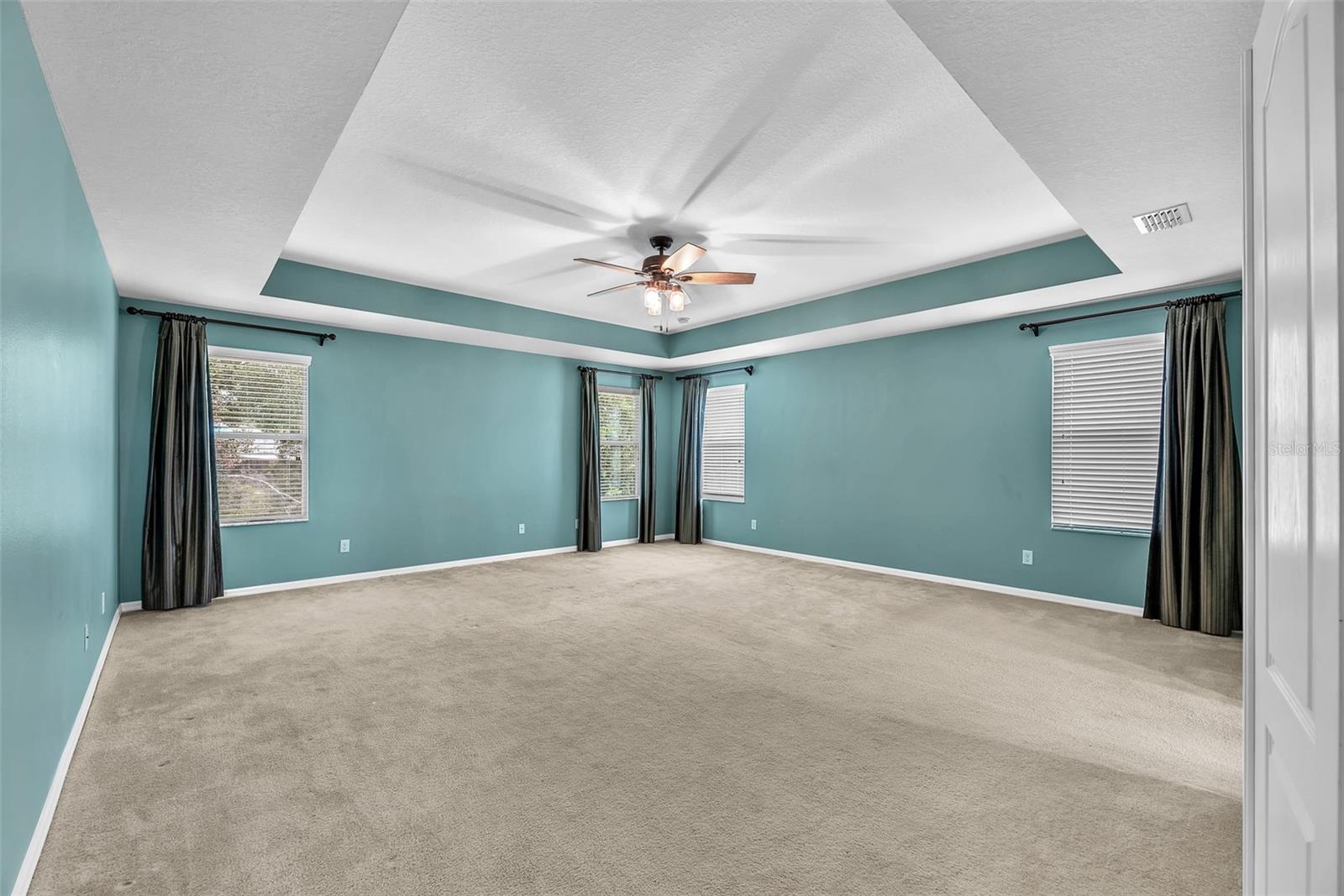 The luxurious owner’s suite features tray ceilings, dual walk-in closets with custom built-ins, and a spa-like en-suite bath.