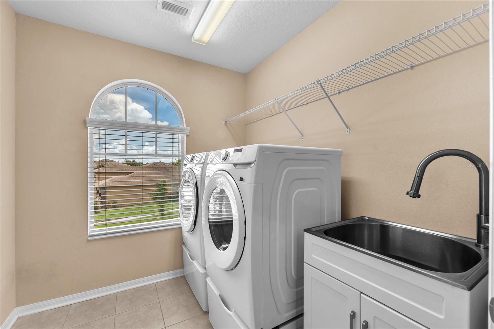 Upstairs laundry roo with washer & dryer and utility sink.