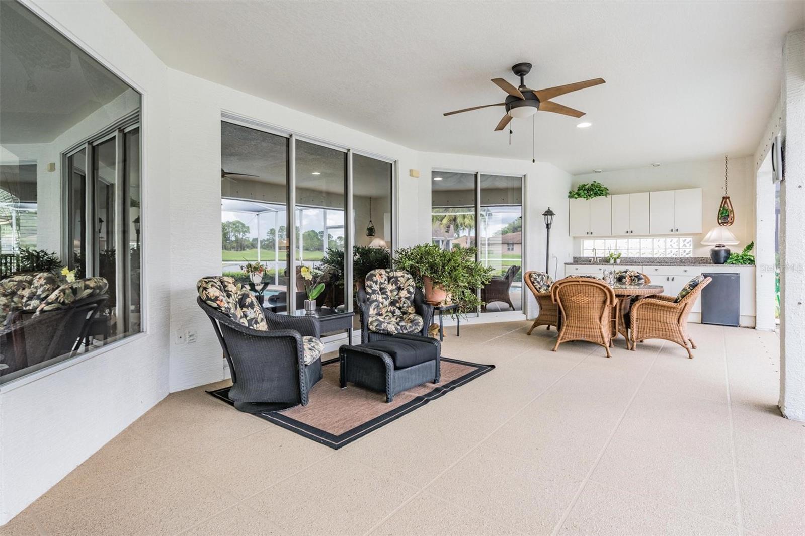 This outdoor living area with outdoor kitchenette means the party is at your house