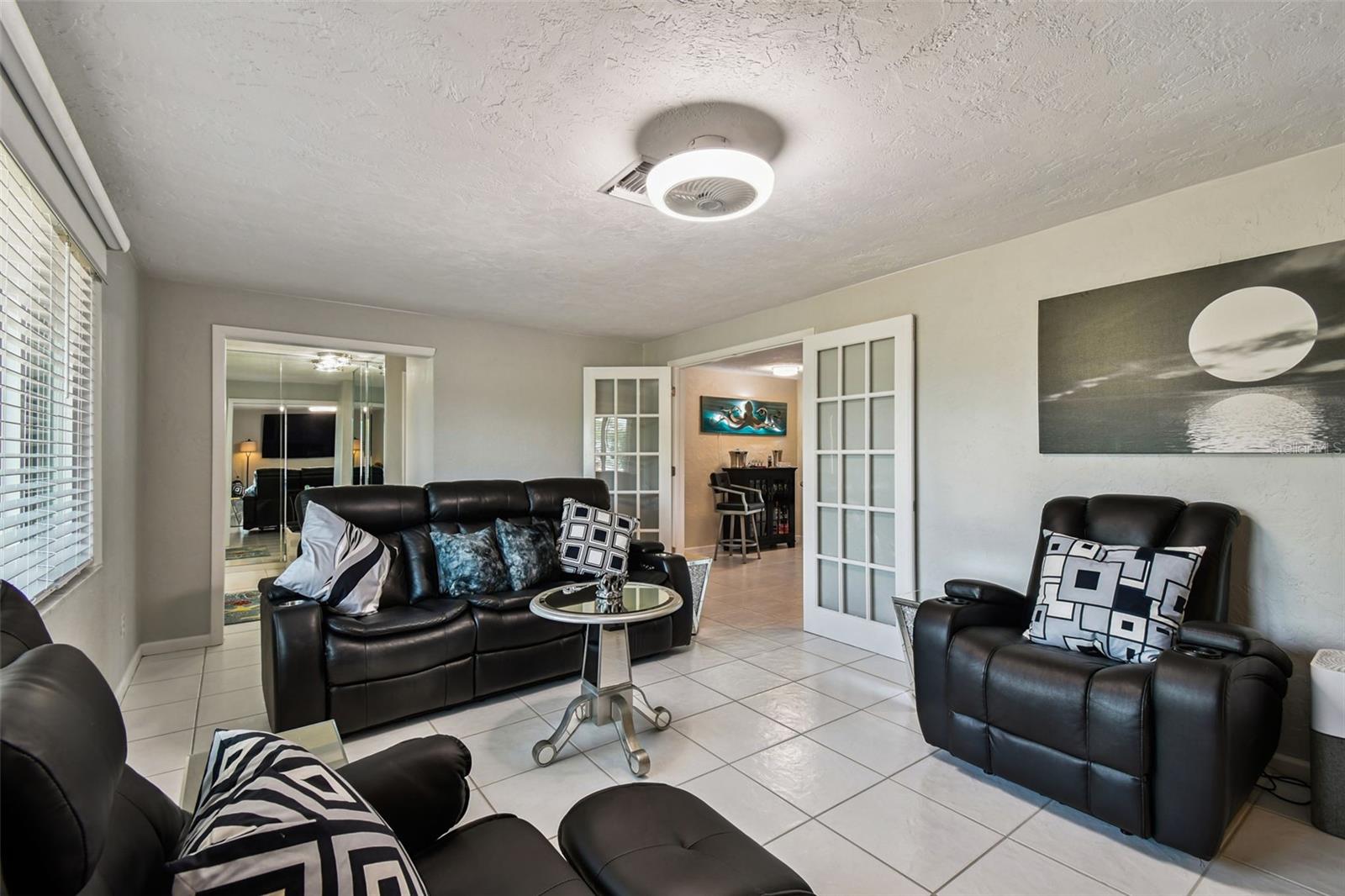 Large formal living room with gleaming white tile and neutral palette