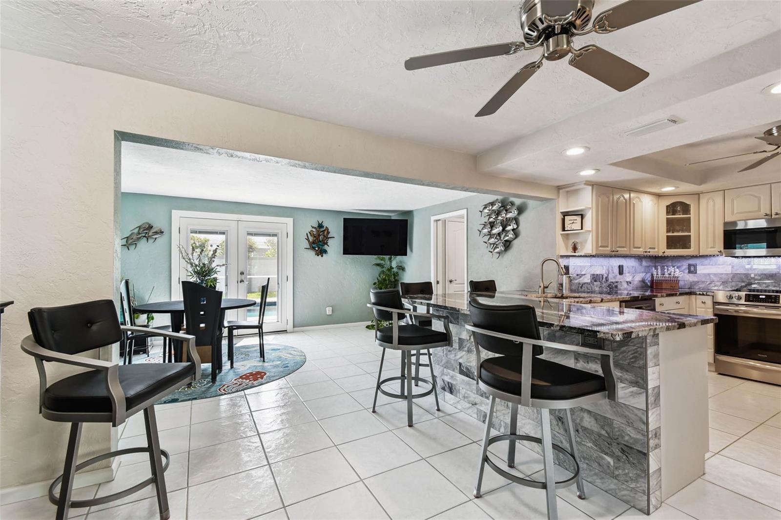 Renovated kitchen with a generous granite countertop bar and custom backsplash
