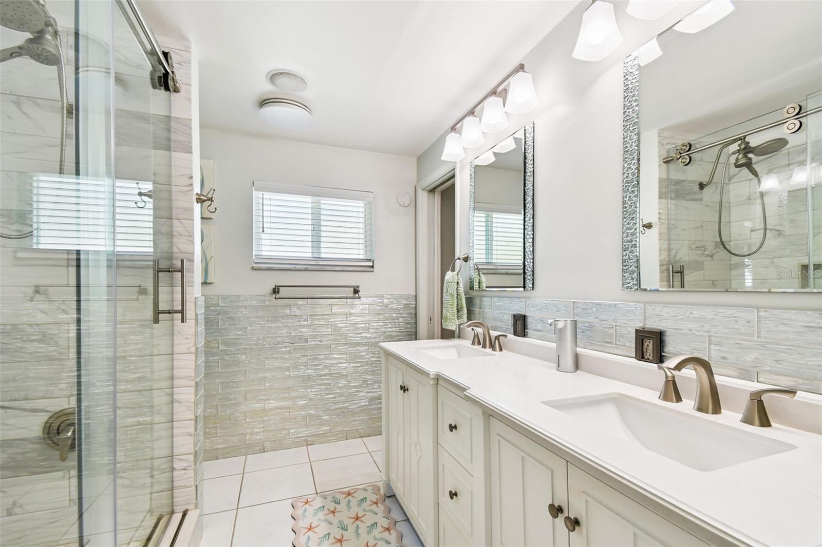 Glamorous bathroom, renovated top to bottom with a double vanity and custom tile work.