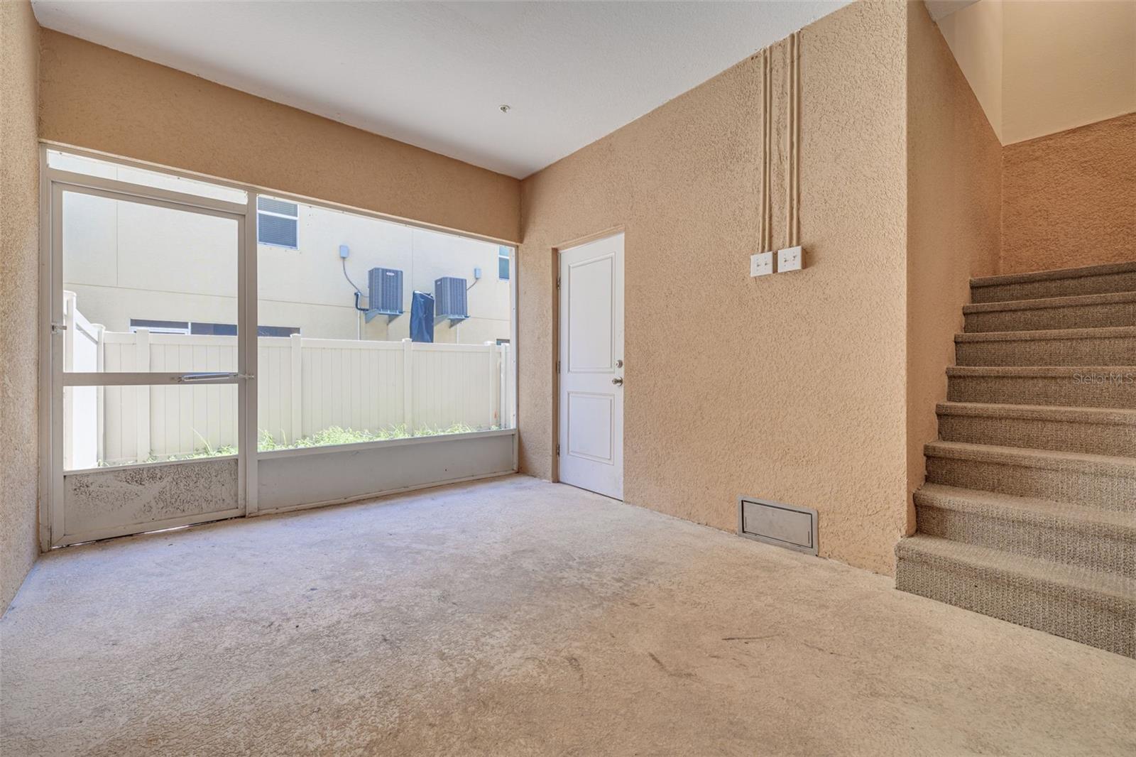 private entry way with 2 storage units and door to fenced in lawn