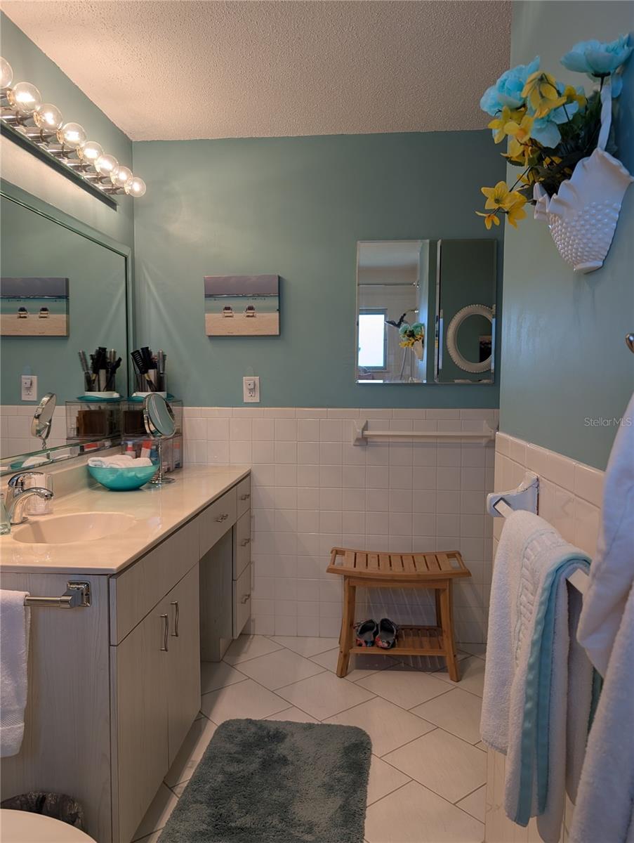View of L shaped bath from shower.  Vanity provides area to sit and get ready to start the day.