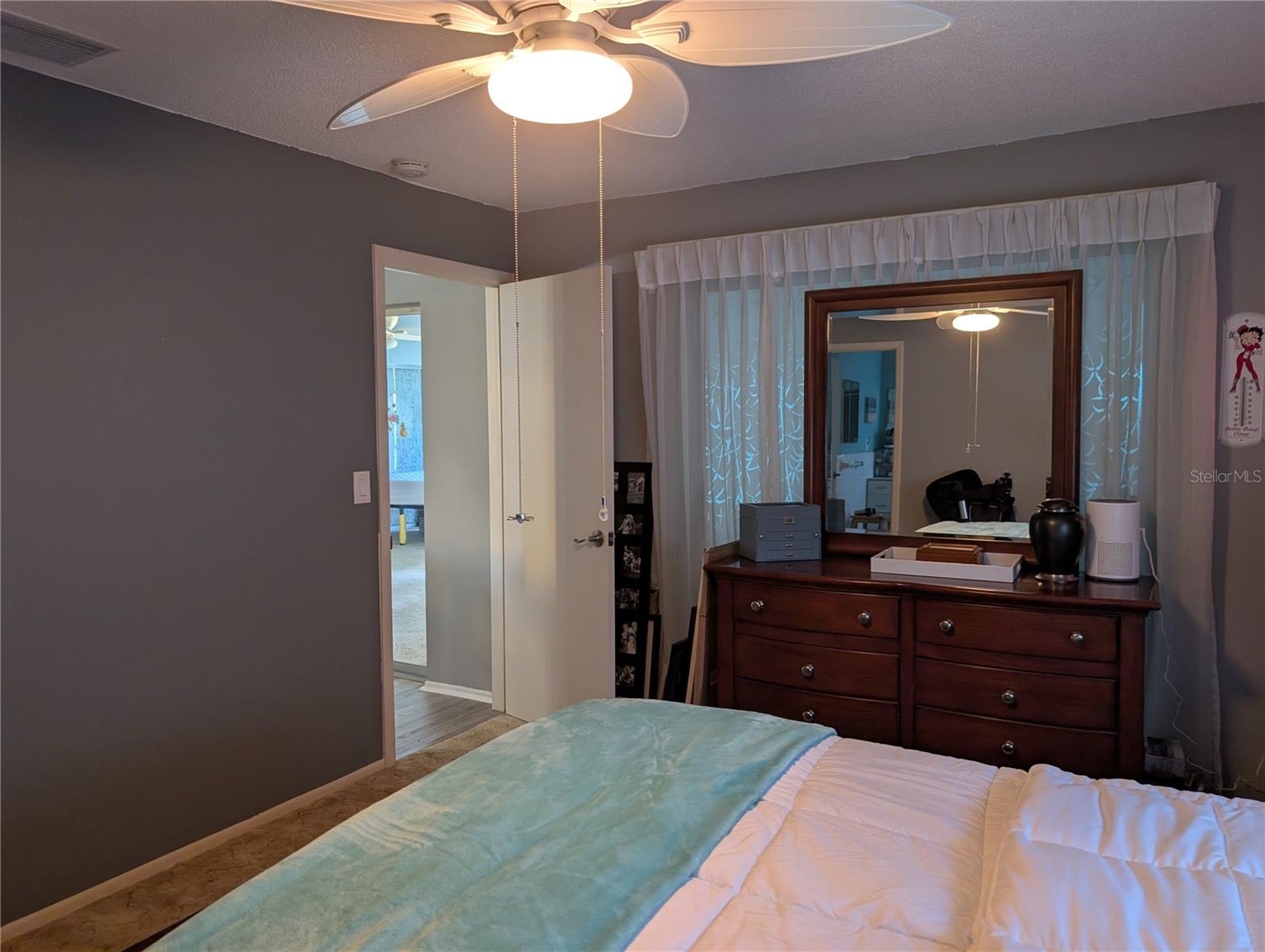 View thru primary bedroom to exit to dining area.  Sliding glass door (behind dresser) leads to Florida room.