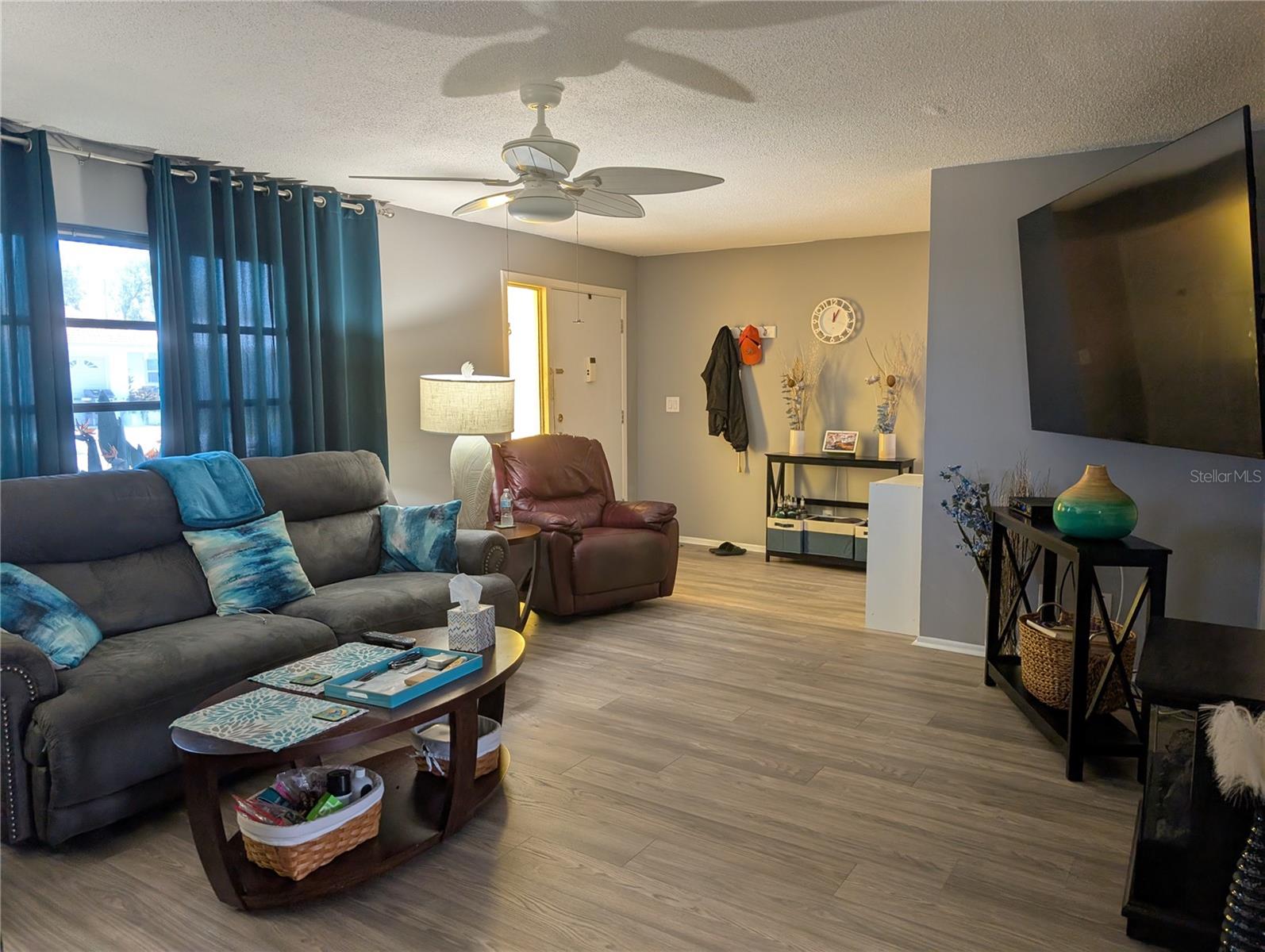Living room to front entry.  Hallway leads into kitchen and Bonus room area.  Pantry located in hallway.  Living has updated ceiling fan and 75" Sony TV...which stays.