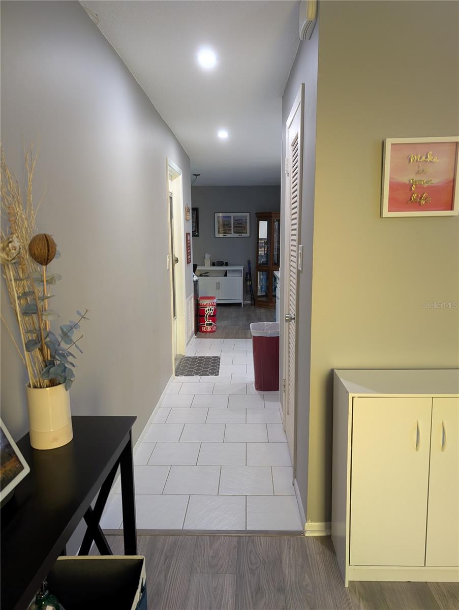 Hallway view from front entry thru living room to kitchen and bonus room area where guest area is located.  Access to garage on left, pantry on right.