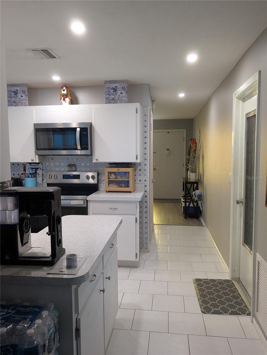 Hallway view from Bonus area thru kitchen to front entry.  Garage access on right.