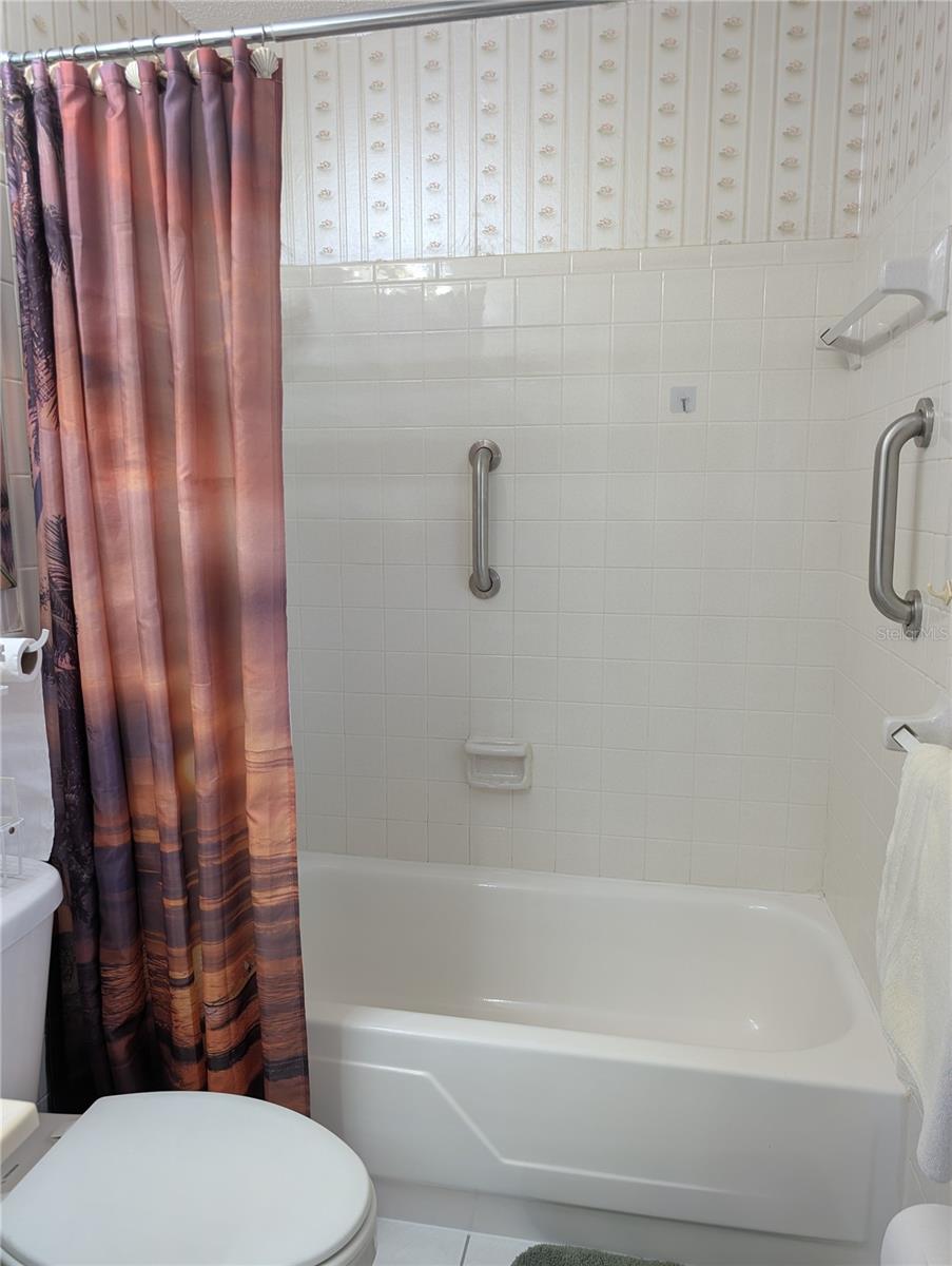 Tub area has safety grab bars installed.