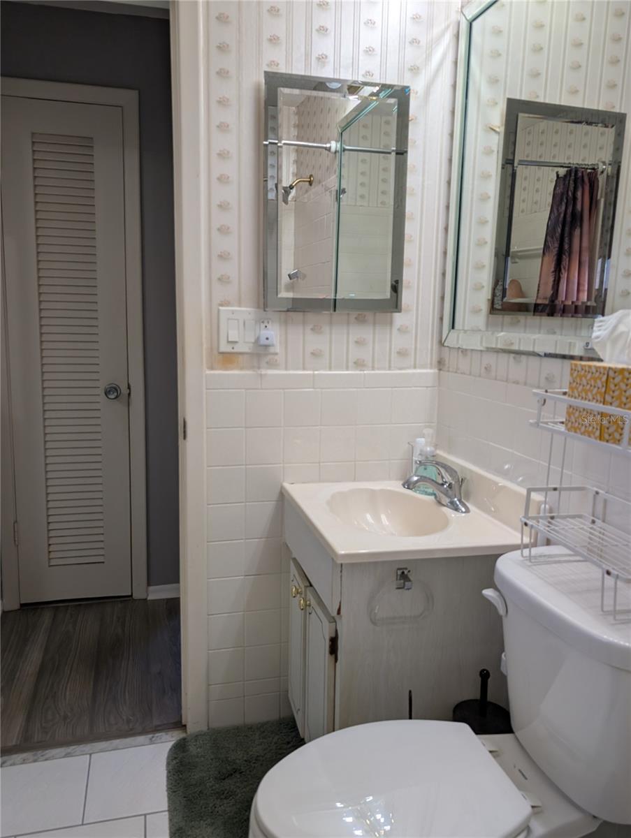 View of bathroom from tub to linen closet in hall.  Guest bedroom to right of linen closet.