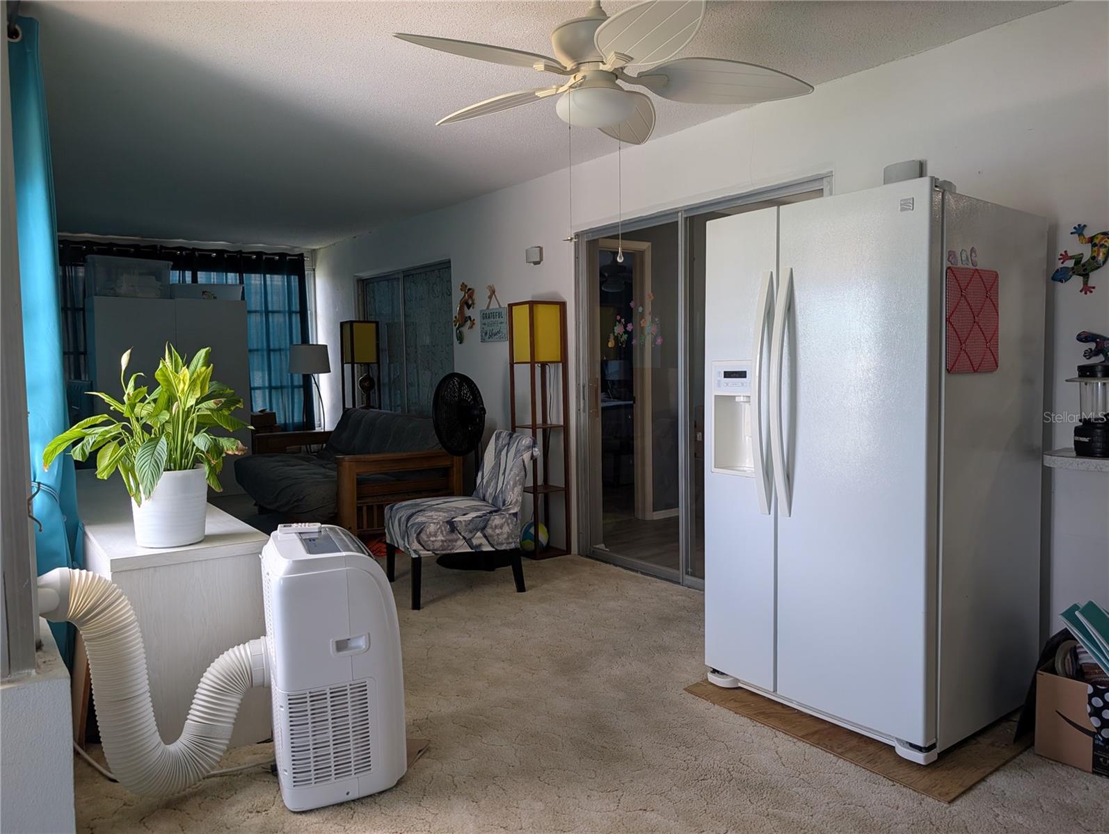 View of dining room and primary bedroom access.  Portable AC unit does not convey.