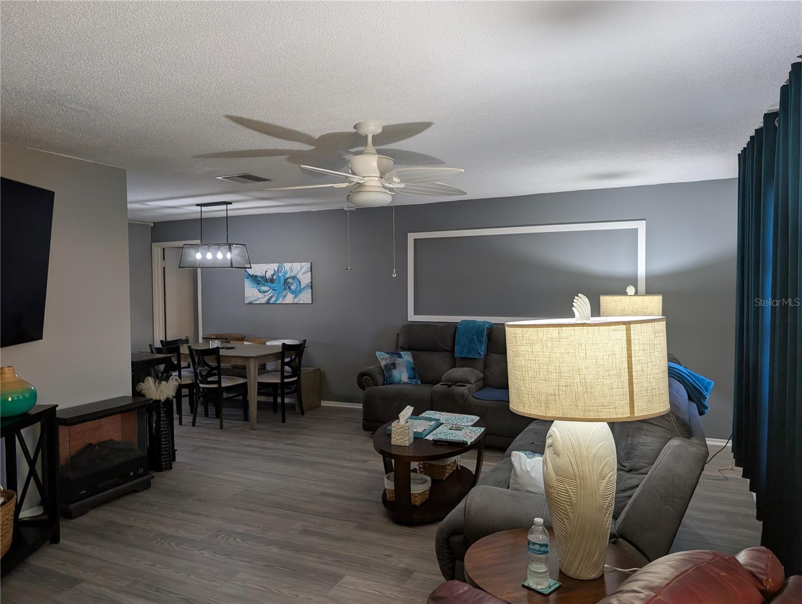 View of living room from entry thru dining room ending at primary bedroom entrance. Living area features brand new Luxury Vinyl flooring.