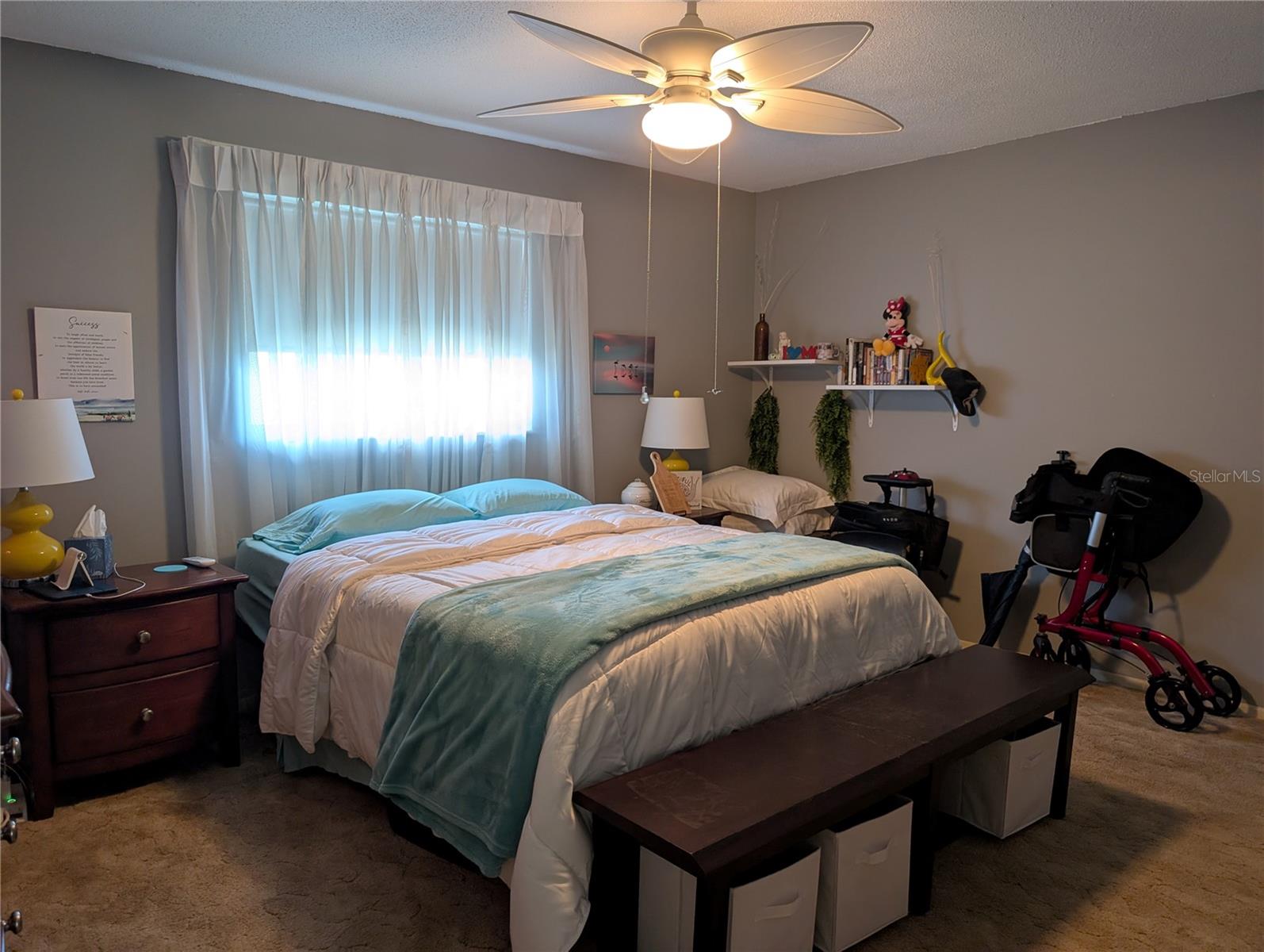 Spacious primary bedroom features carpeting, ceiling fan and ensuite bathroom.