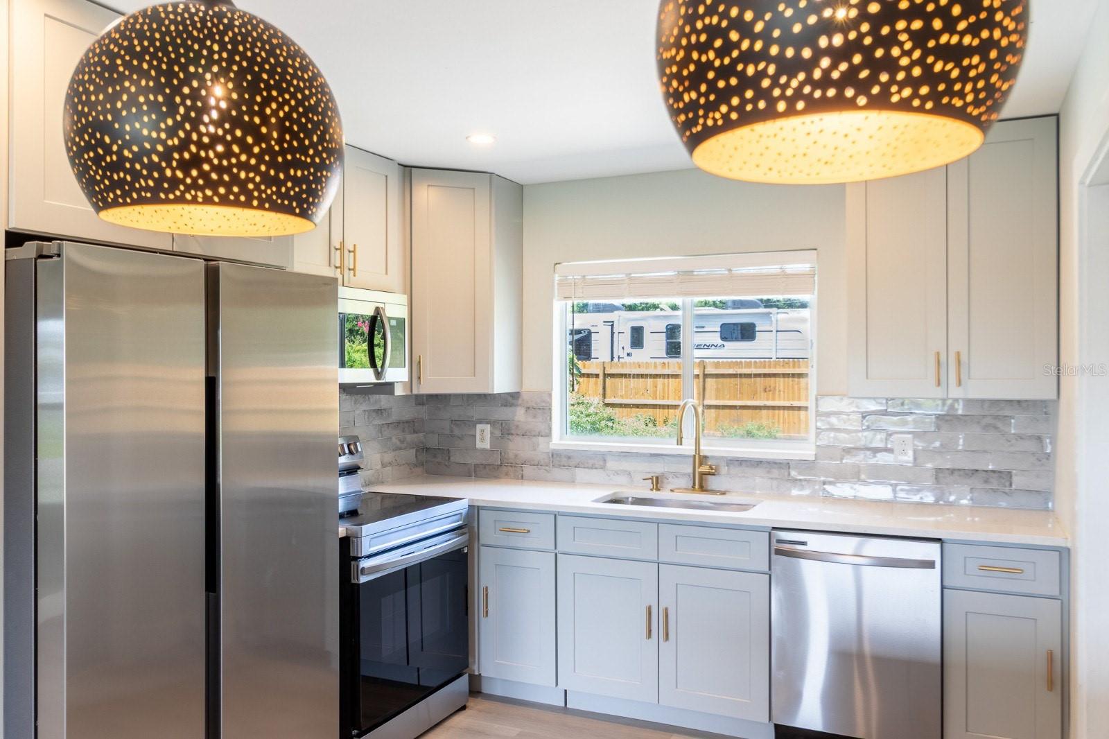 New kitchen with all new appliances, cabinets, lighting and breakfast bar with storage