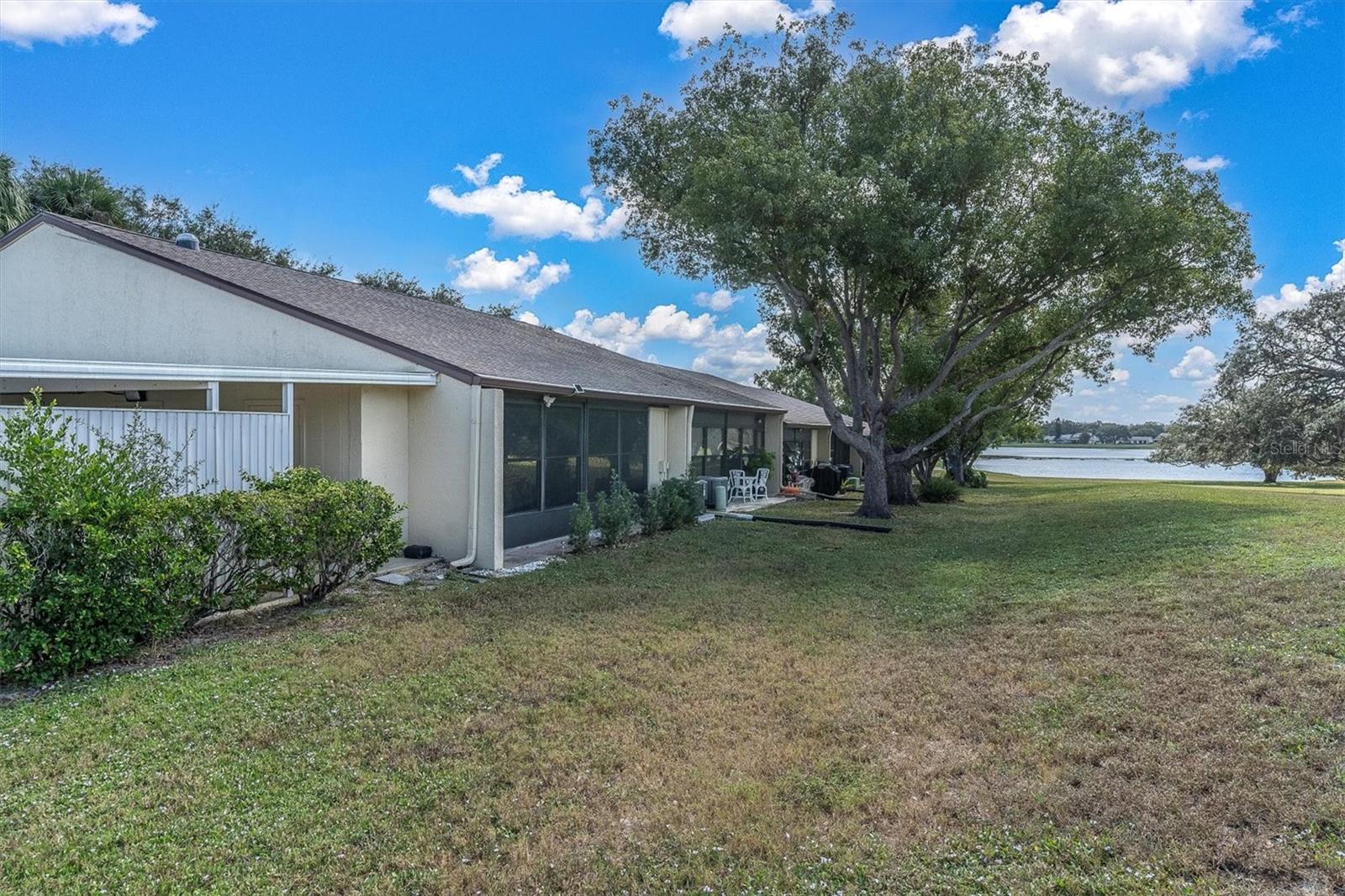 Rear of condo. Adjacent to carport area and view of pond